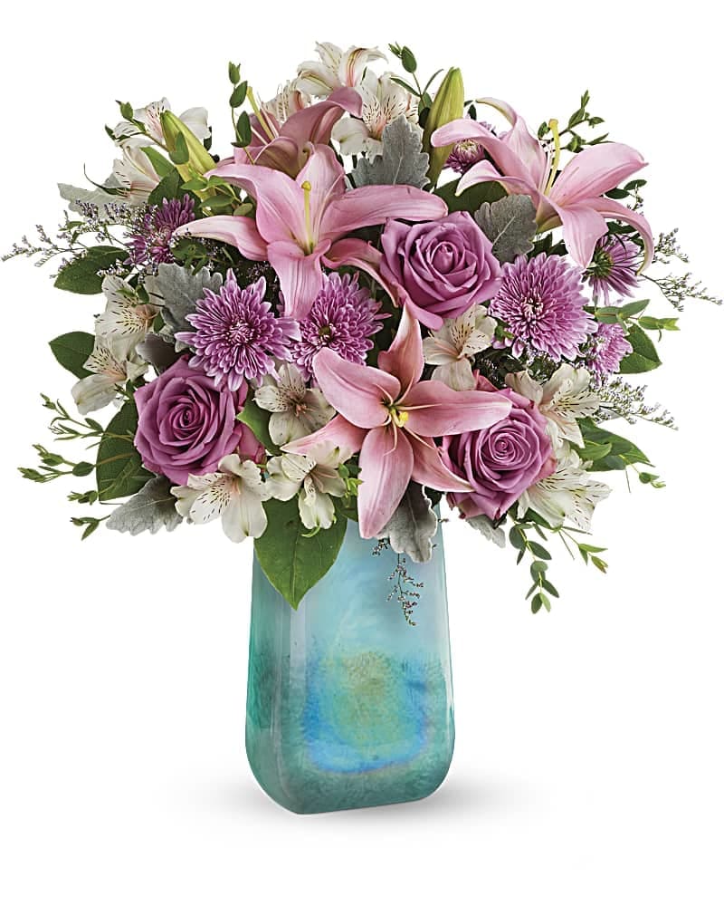 Pink lilies and roses in a blue glass vase