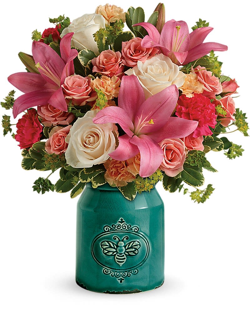 Pink lilies and roses arranged in a teal vase with a bee design