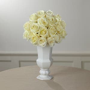 Cream rose bouquet in a white pedestal vase