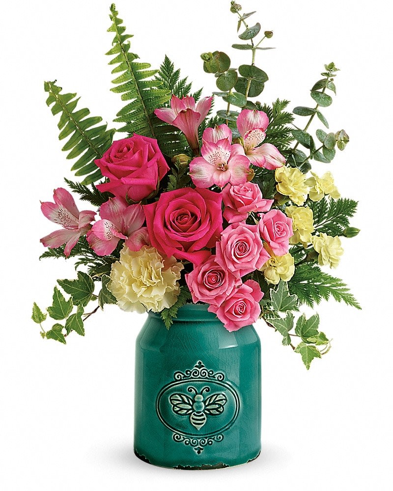 Pink roses and alstroemeria in a teal vase with fern foliage