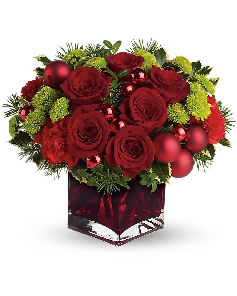 Teleflora's Merry &amp; Bright - You may not be able to guarantee a white Christmas, but with elegant touches like stunning red roses mixed with ornament balls and douglas fir, you can be assured of sending a merry and bright one! Gorgeous red roses and carnations along with brilliant green button chrysanthemums, shiny red ornament balls and winter greens are perfectly arranged in this very merry Christmas cube. (z)