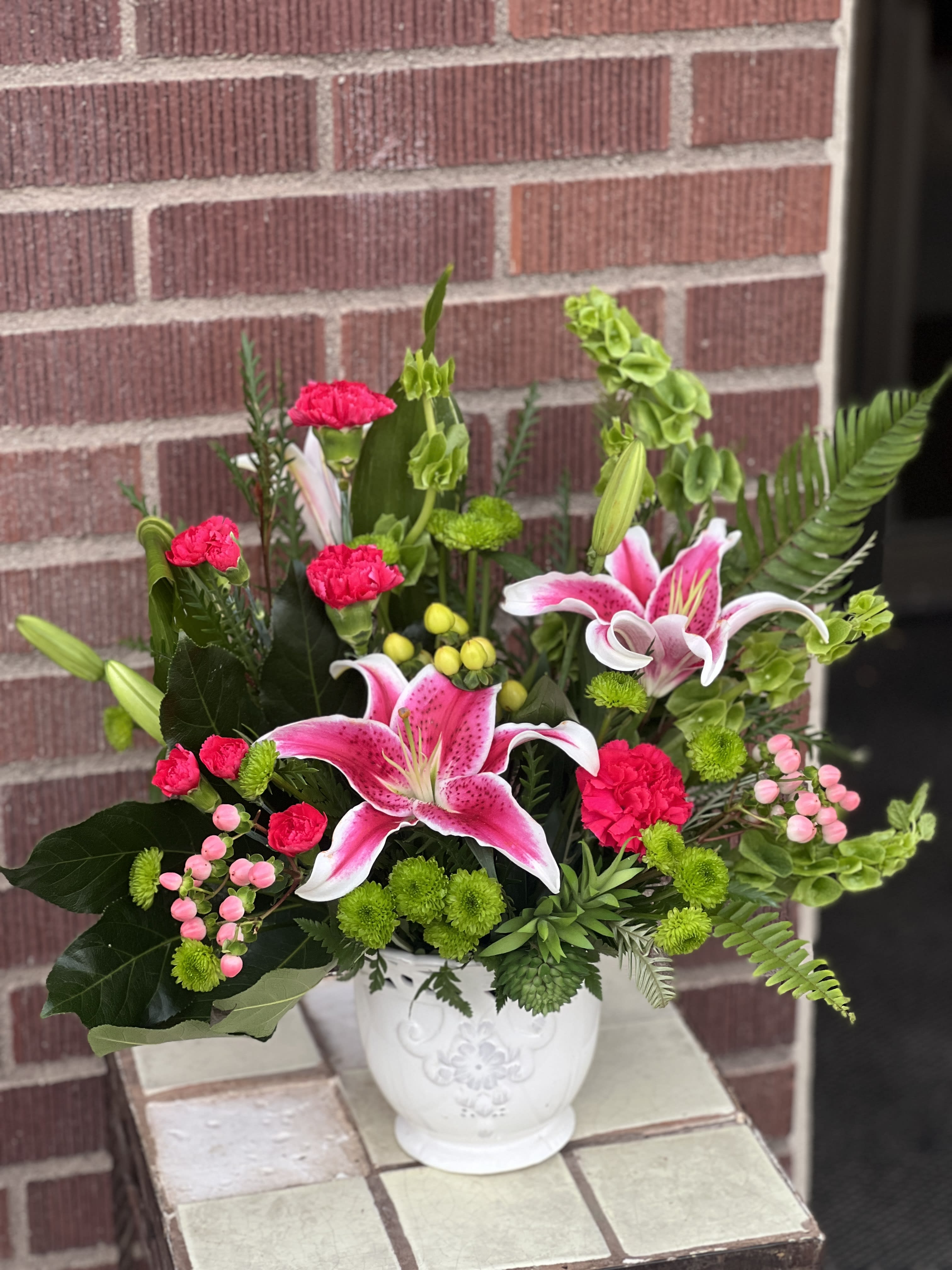 Pink lilies and carnations in a white vase