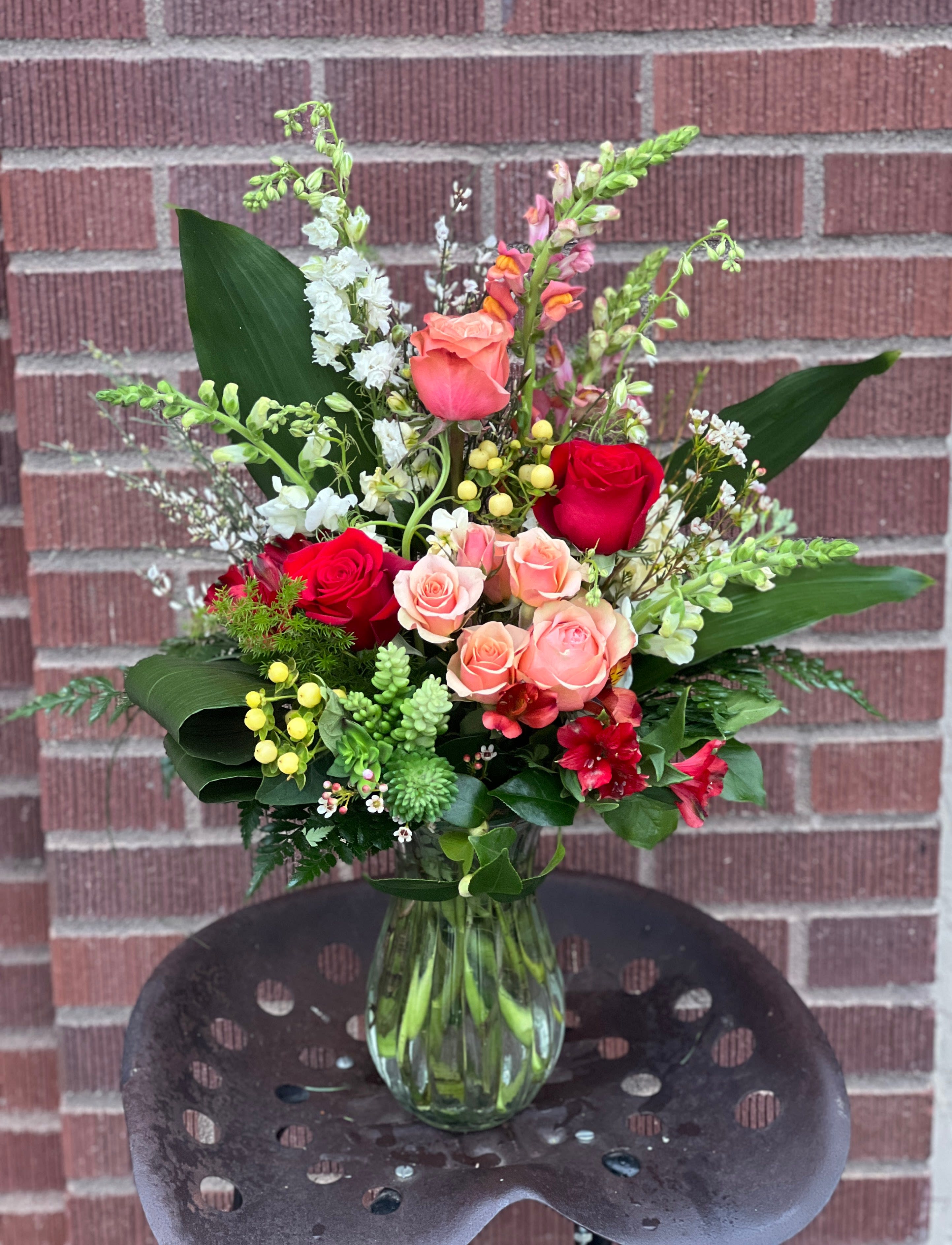Mixed bouquet of roses and snapdragons in a glass vase