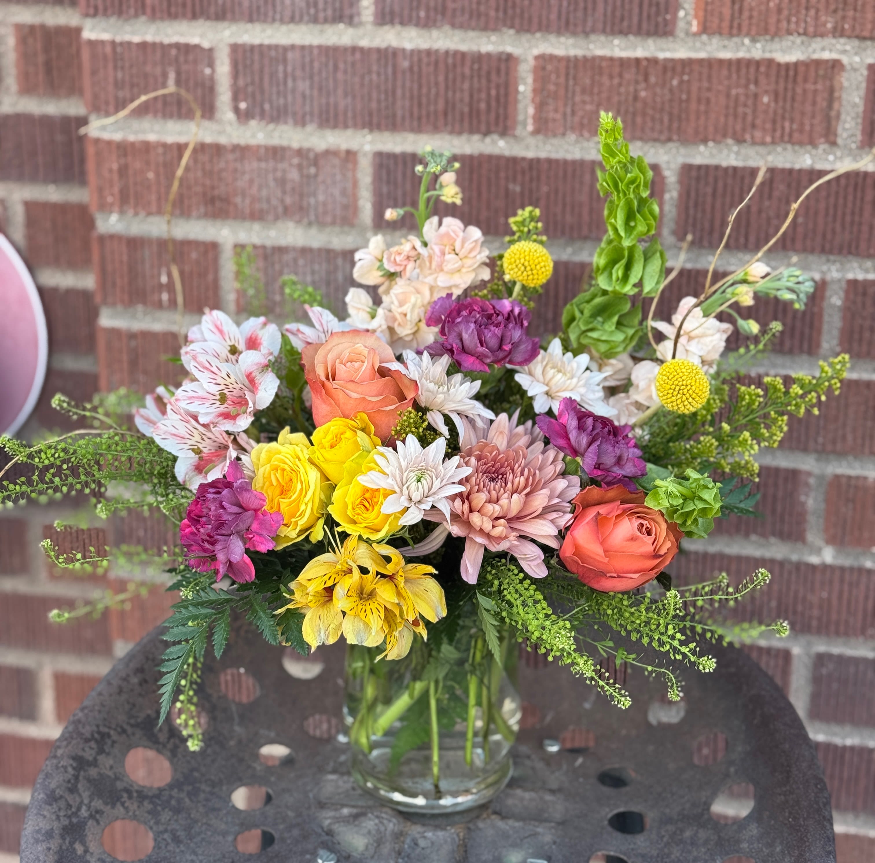 Mixed bouquet in a clear glass vase with roses, chrysanthemums, and alstroemeria