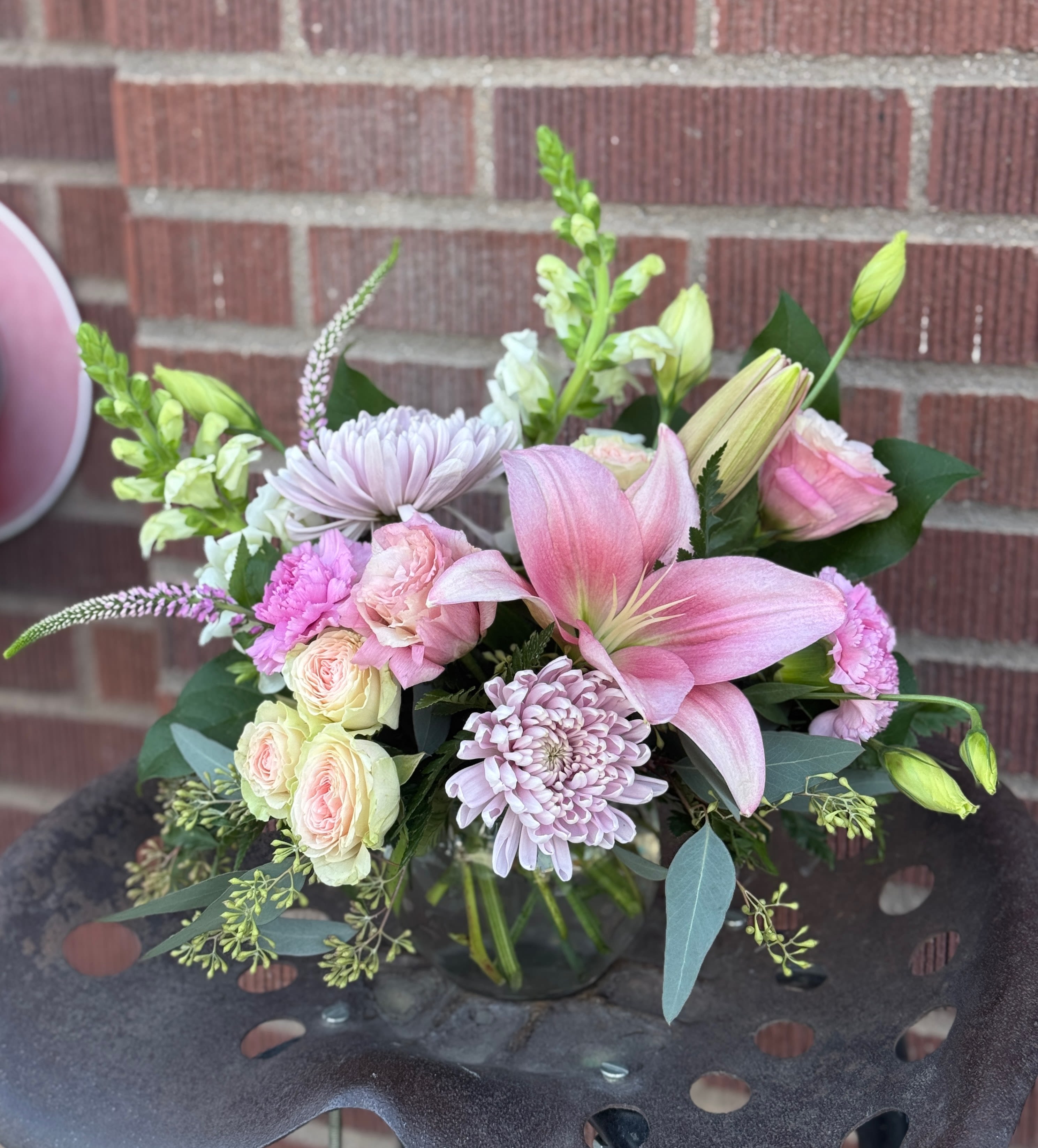 Pink lilies and pastel roses in a glass vase