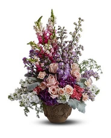 IN THE GARDEN - In the garden, fresh flowers bloom and nature's beauty reigns. Send this pastel medley of blossoms to a residence, funeral home or memorial service to show your deep devotion and affection. A mix of fresh flowers such as roses, delphinium, stock, snapdragons, hydrangea and Monte Cassino asters is arranged in Teleflora’s Garlands of Grace urn.  Approximately 20" (W) x 26" (H)
