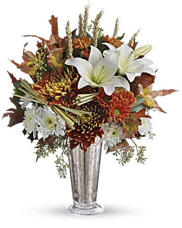 Autumn bouquet of white lilies and orange chrysanthemums in a silver vase