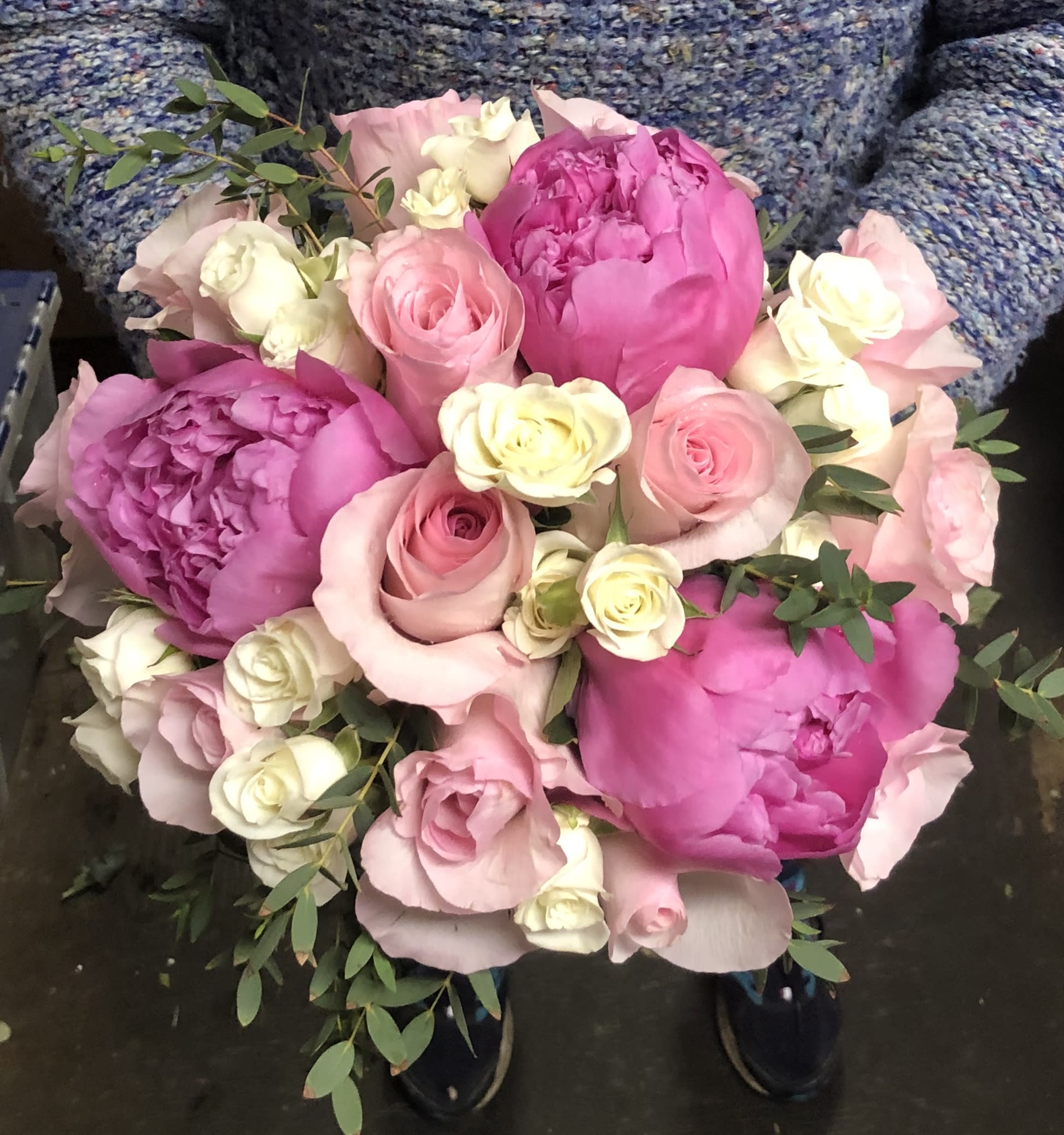 Bouquet of pink peonies, roses, and white mini roses with greenery