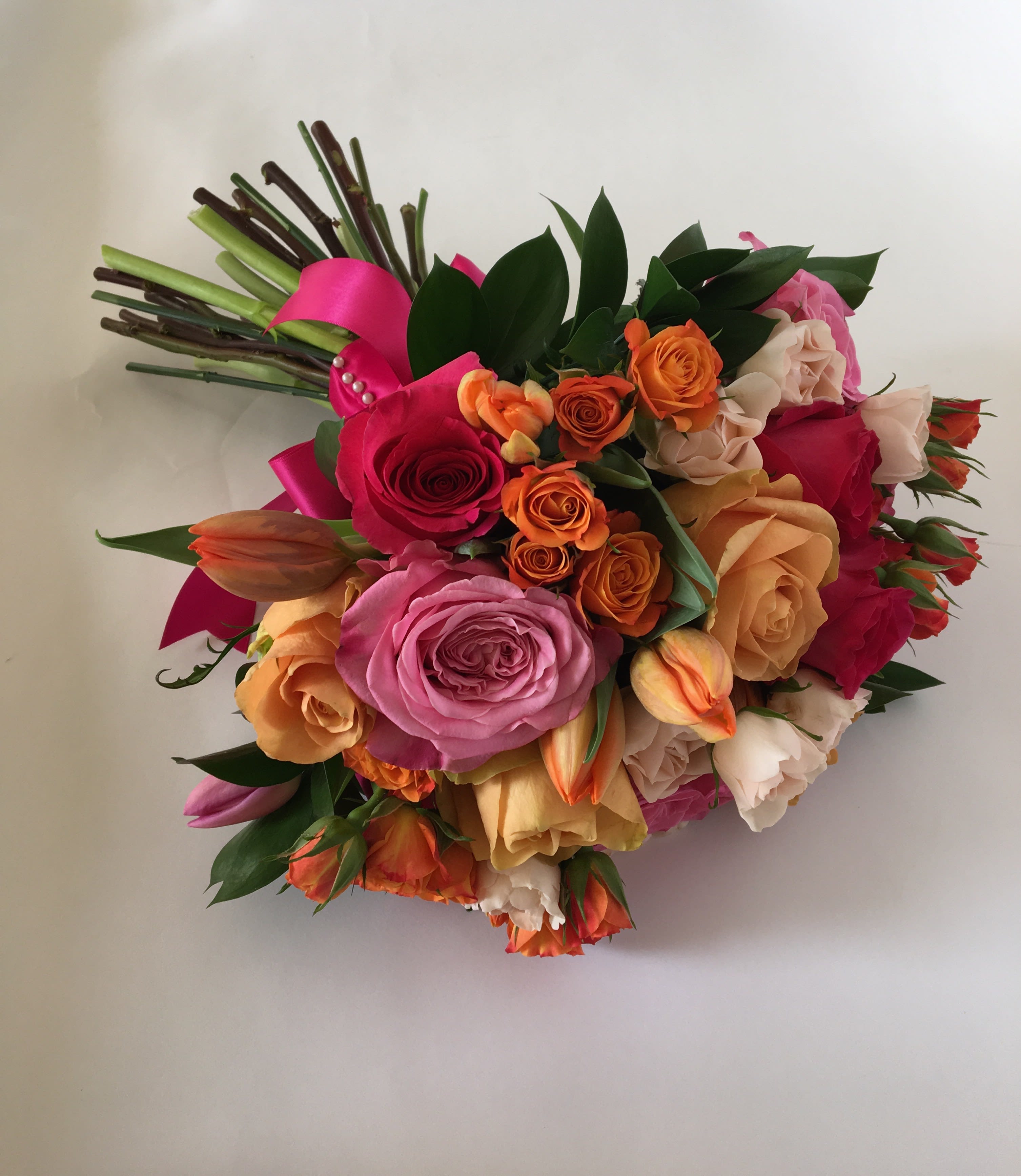 Colorful bouquet of roses and tulips with a pink ribbon