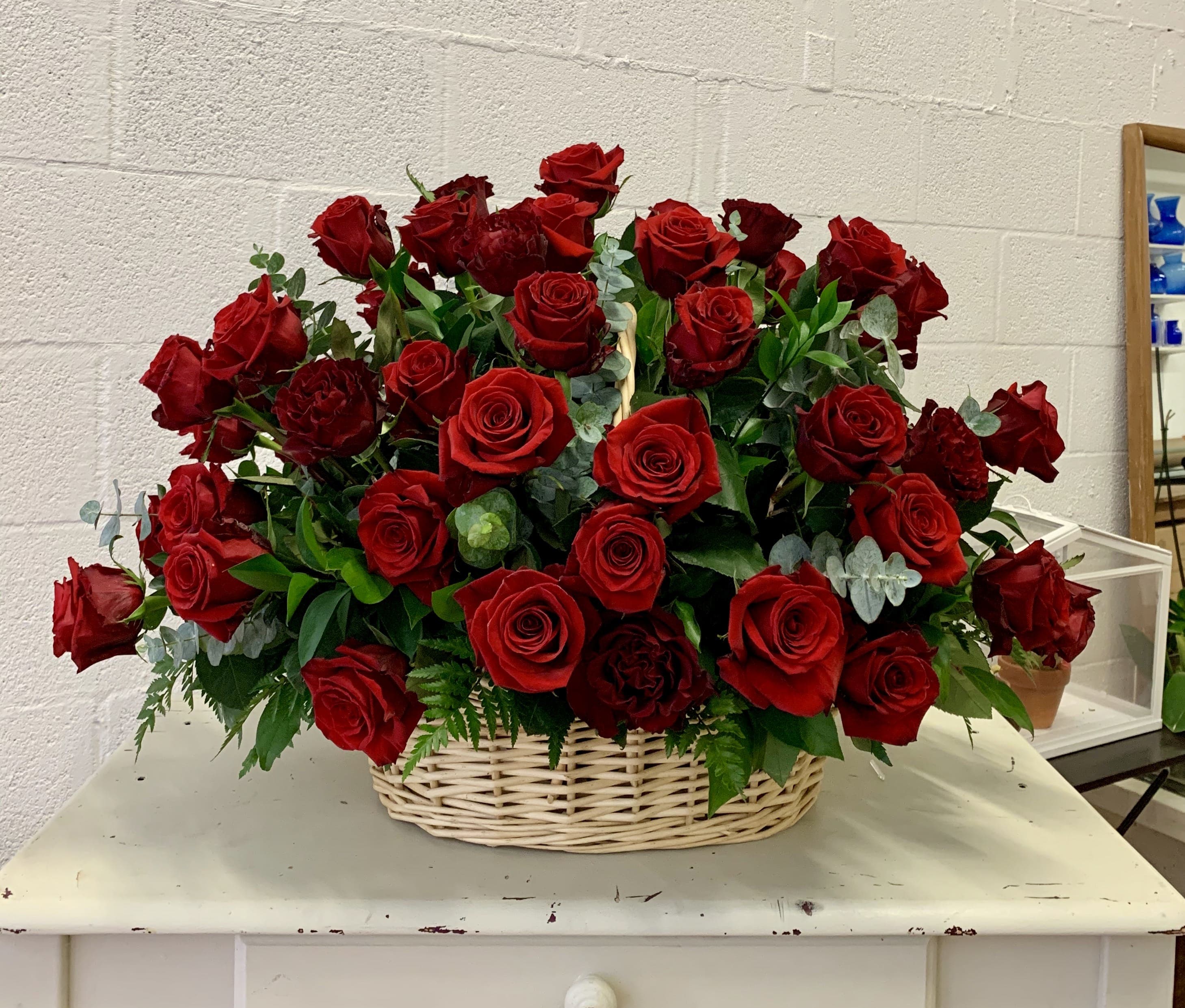 Basket of red roses with greenery