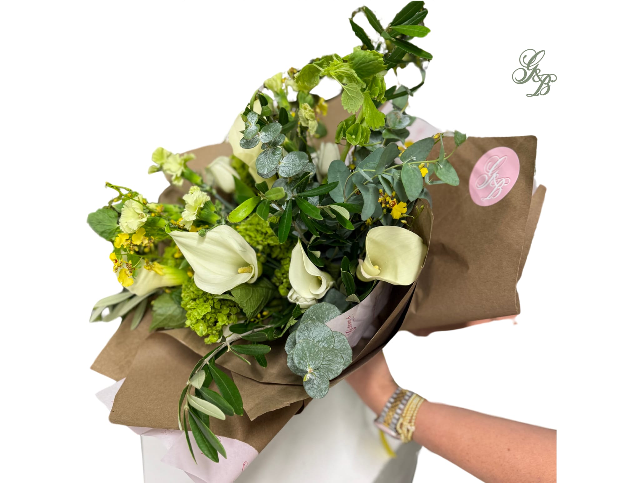 Bouquet with white calla lilies and green flowers wrapped in brown paper