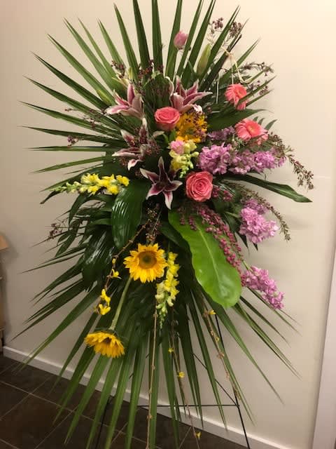 Tall standing floral spray with pink, yellow, and purple flowers