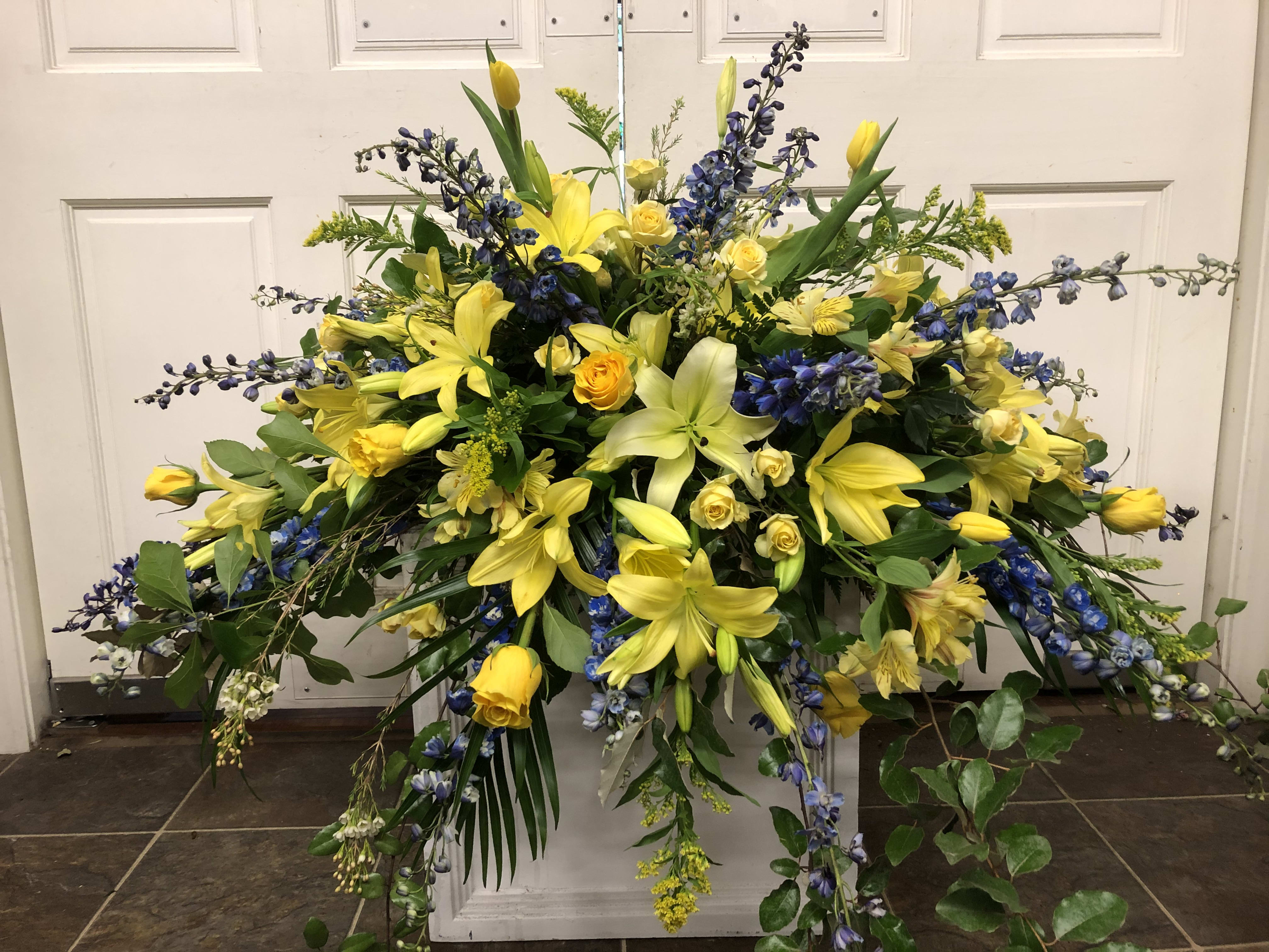 Large yellow and blue floral spray with lilies and roses