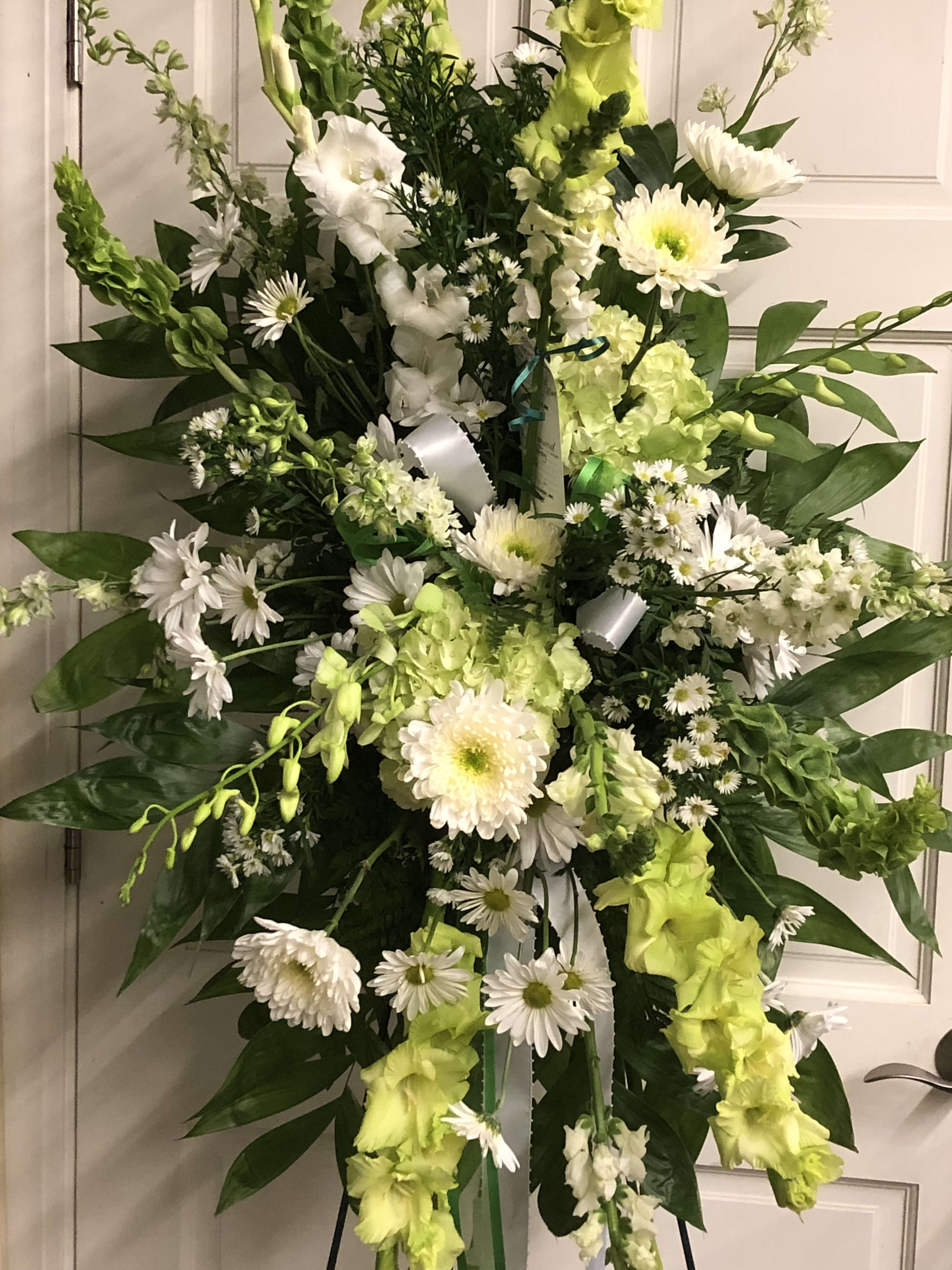 Tall white and lime-green floral standing spray on an easel