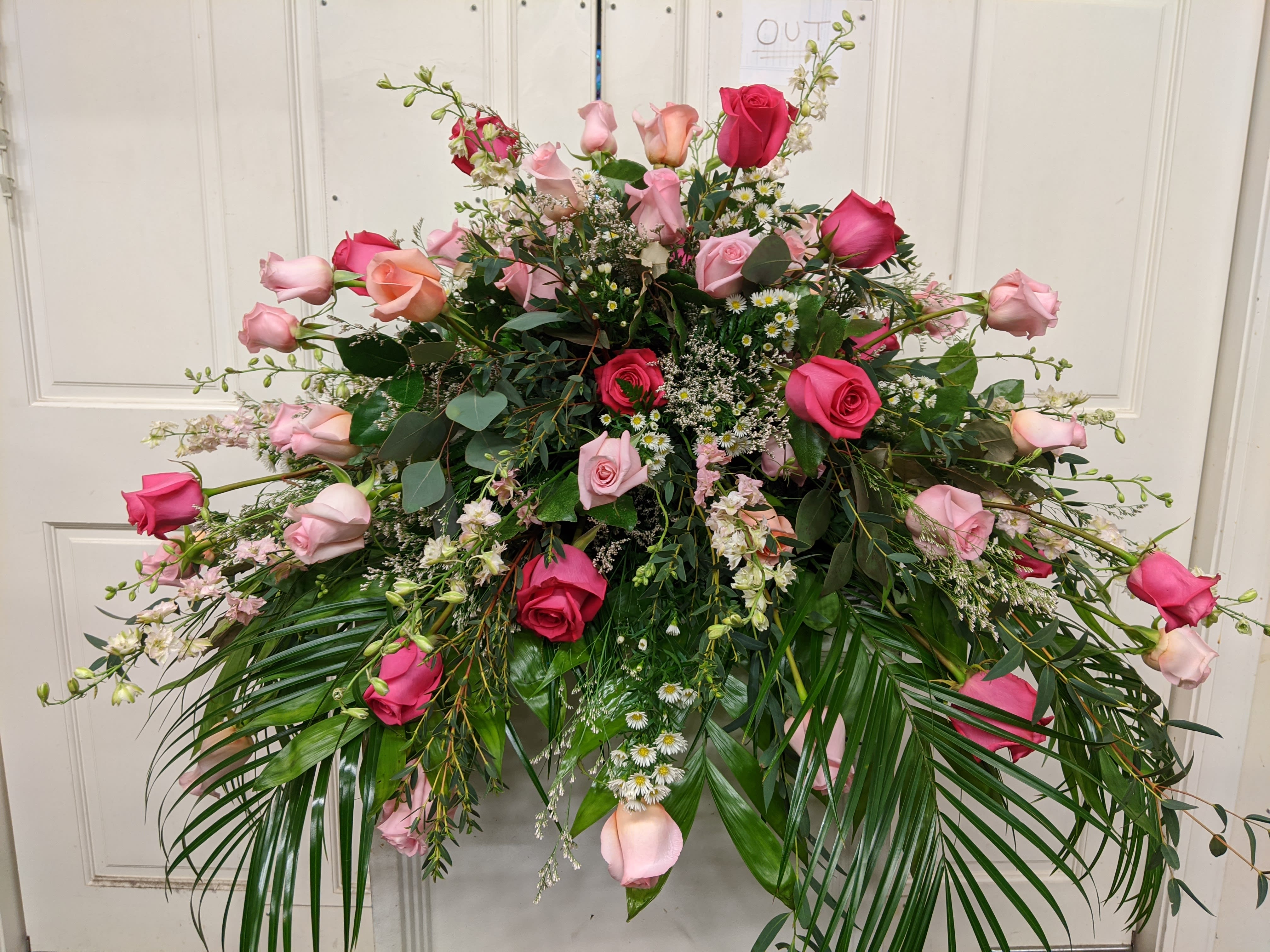 Large pink and red rose arrangement with cascading greenery