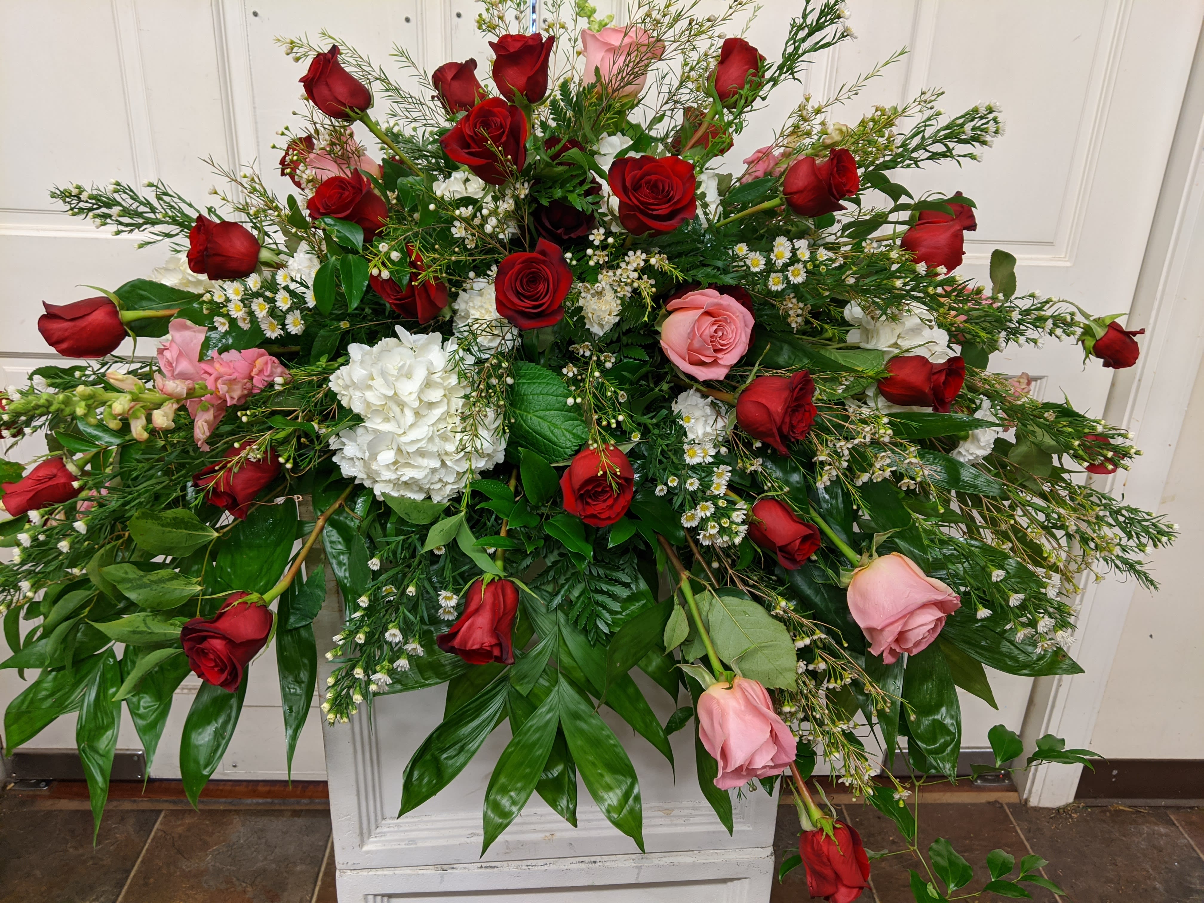 Large floral spray with red and pink roses and white blooms