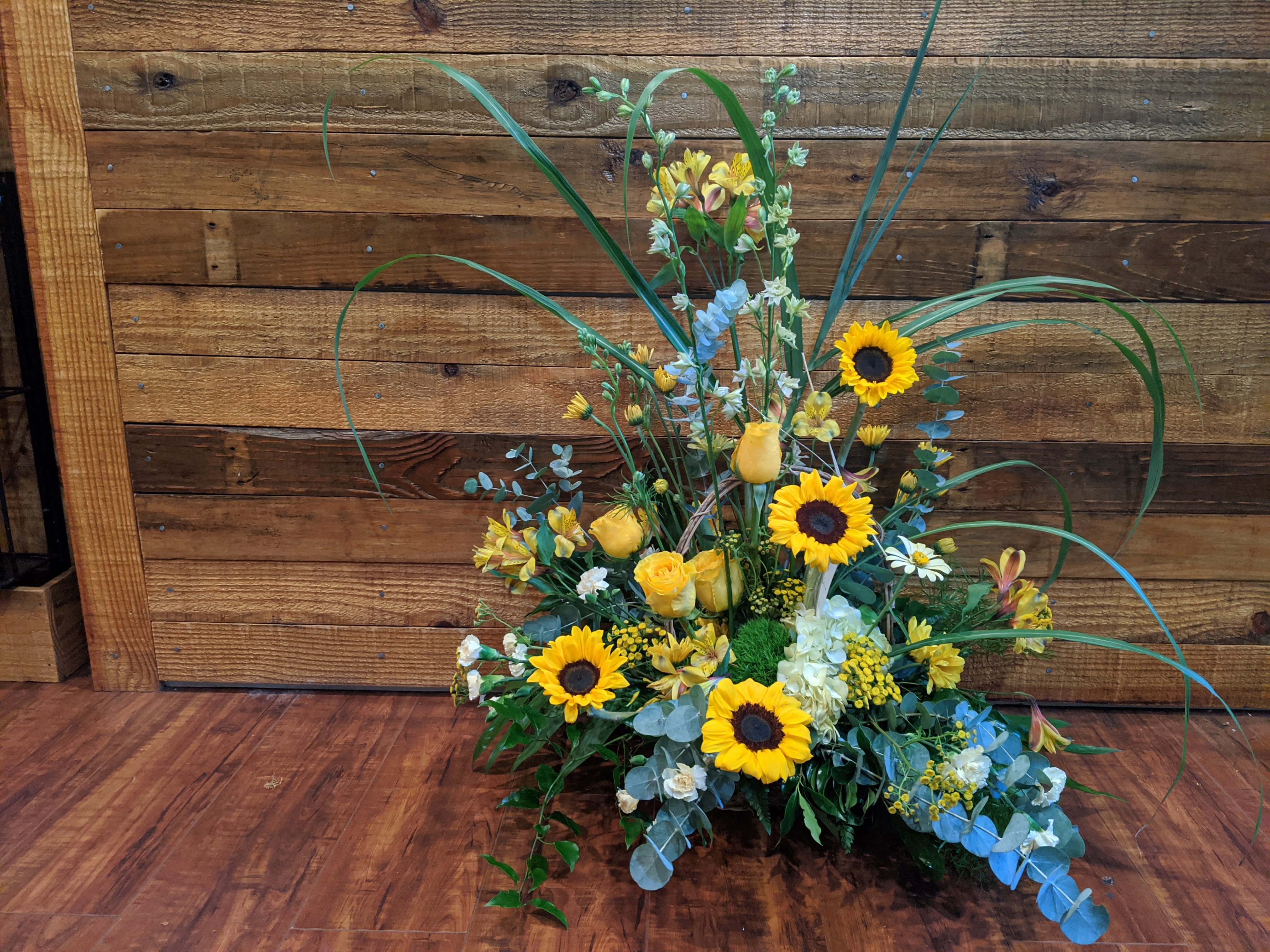 Tall floral arrangement with sunflowers and yellow roses