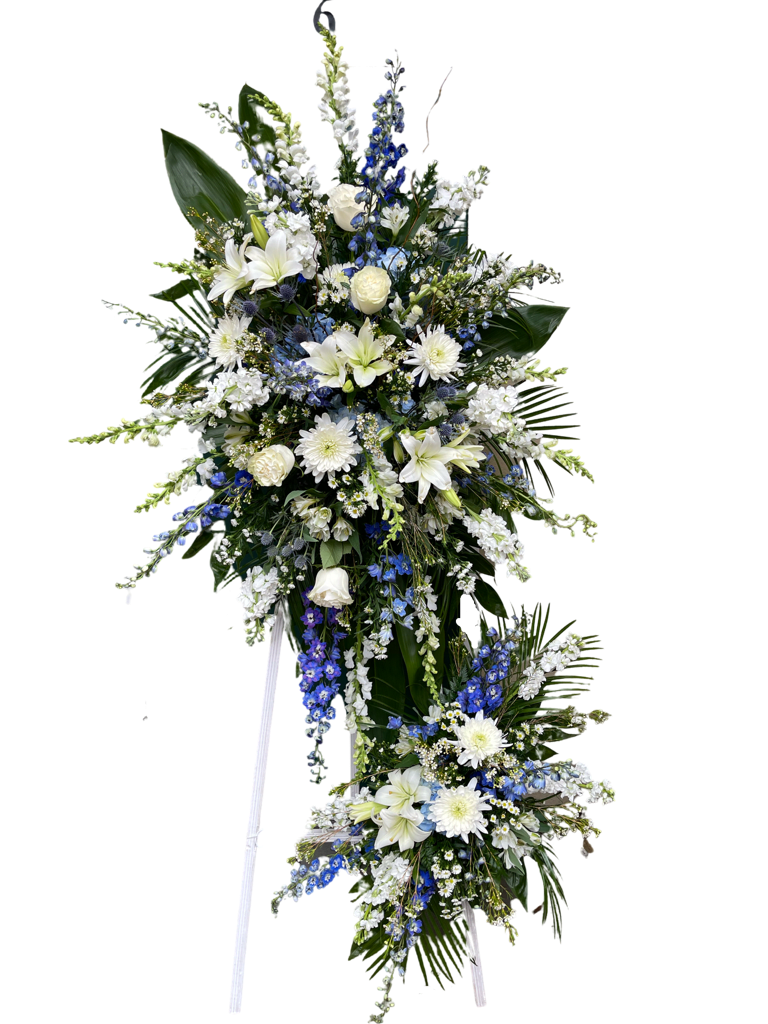 Standing floral spray with white and blue flowers on a white easel