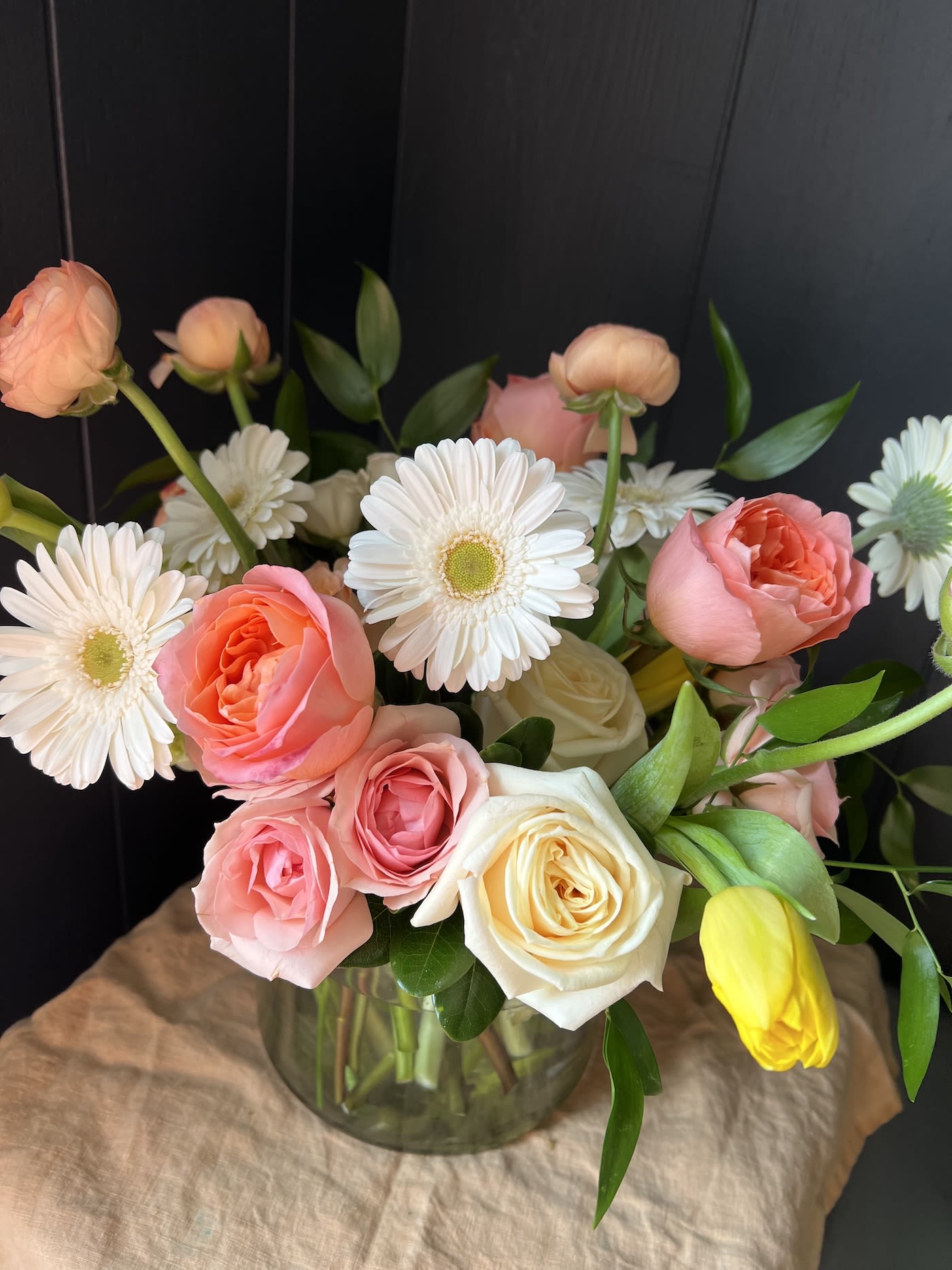 Pink and white roses with white daisies in a glass vase