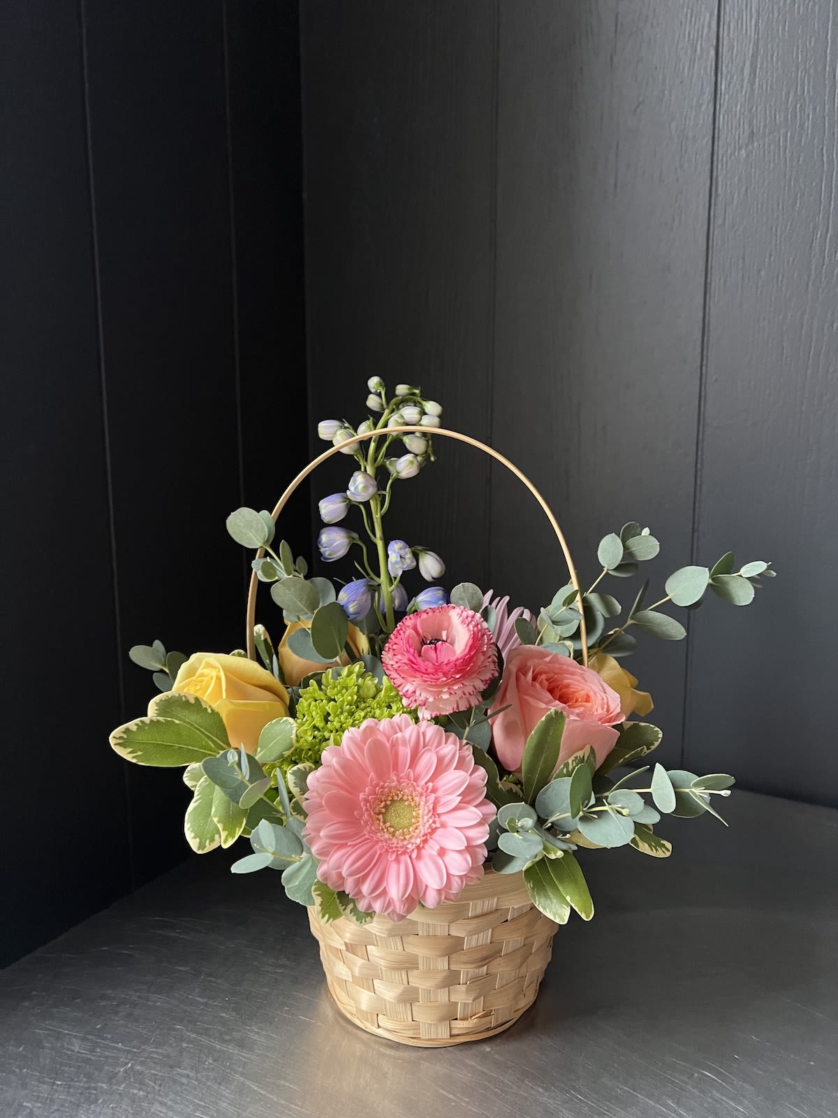 PETITE SEASONAL BASKET - Seasonal, colorful flowers and foliage artfully arranged in circular woven basket.  Year round flowers that we typically stock: specialty rose, spray rose and garden rose, ranunculus, anemone, gerbera daisy, protea, lisianthus, chrysanthemum, larkspur, snapdragon, delphinium, stock, aster, dianthus, hypericum, feverfew, astrantia, leucodendron