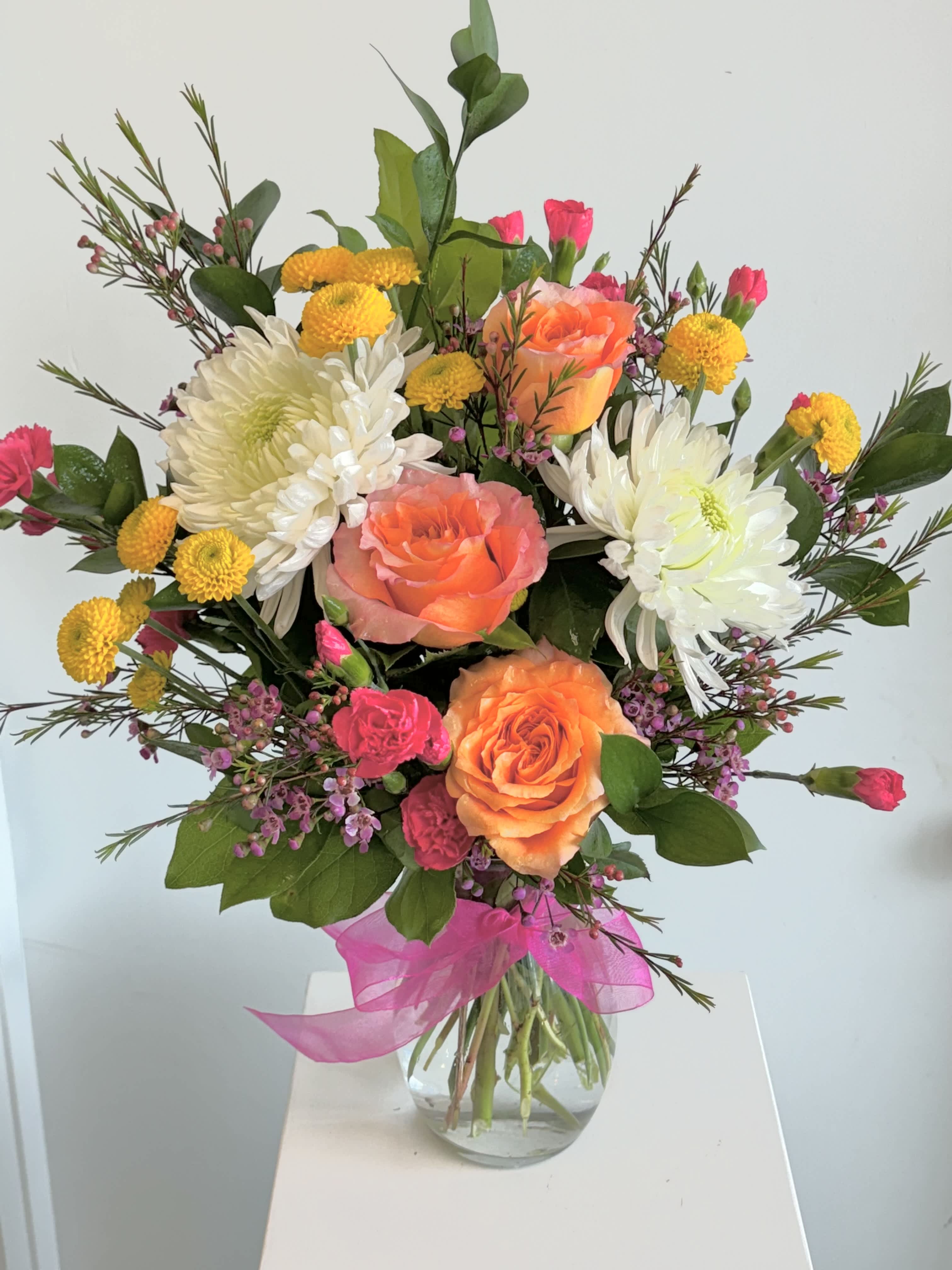 Madison - Bright and cheery colors are a colorful way to express your thoughts.  This bouquet features vibrant oranges, whites and cheery yellow.  It is a great size for a kitchen island, dining room table or coffee table.  Please read our substitution policy.