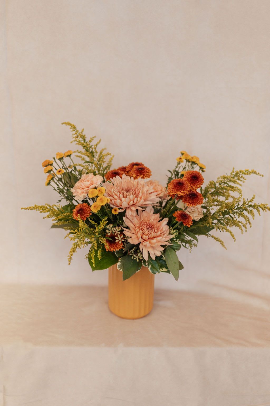 Golden Hour - Just like an Autumn sunset, this bouquet is arranged in hues of butterscotch, oranges, gold and rusts.  Perfect size for end table or kitchen table.  Flowers may vary but overall color and design will remain the same. 