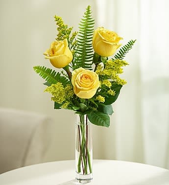 Tall bud vase with three yellow roses and fern accents