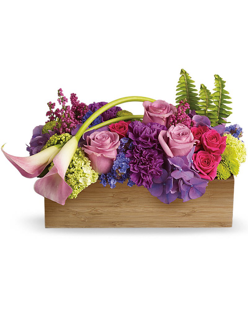 Low rectangular arrangement of purple and pink flowers with calla lilies in a wooden box