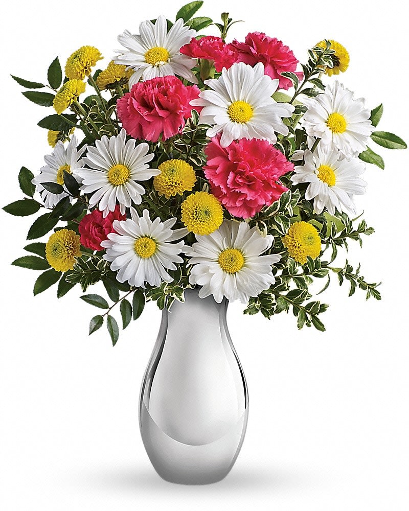 White daisies, yellow button poms, and pink carnations arranged in a sleek white vase