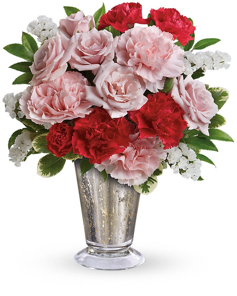 Pink roses and red carnations with white filler flowers arranged in a silver metallic vase.