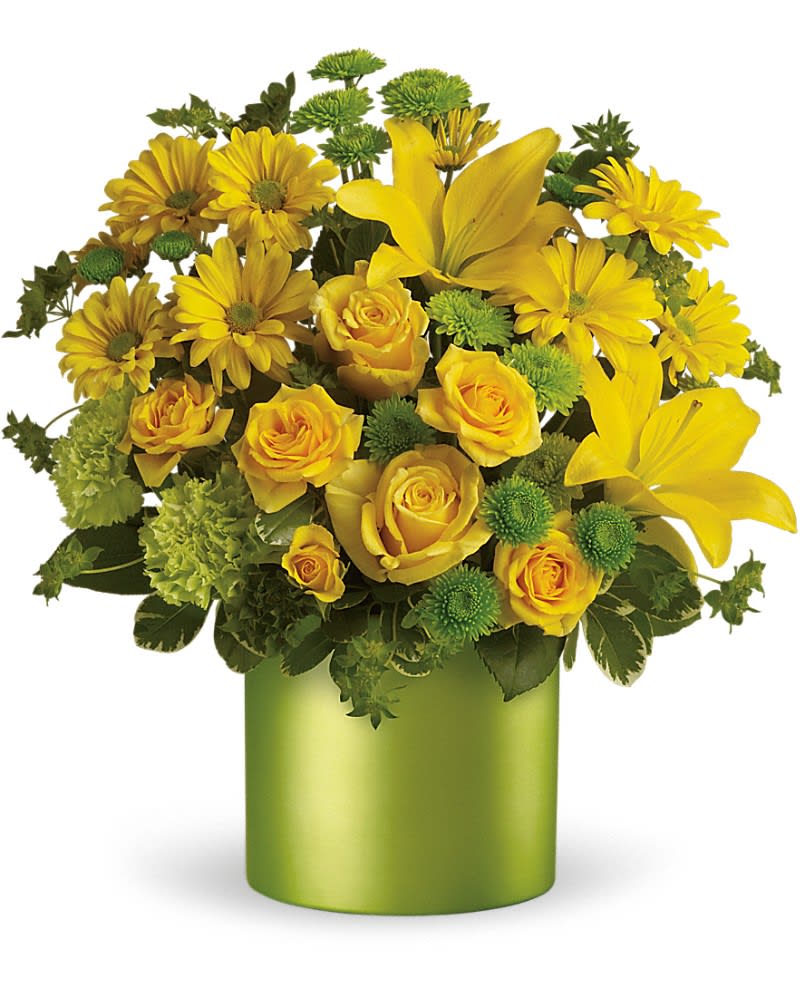 Arrangement of yellow lilies, roses, and daisies with green accents in a green cylinder vase
