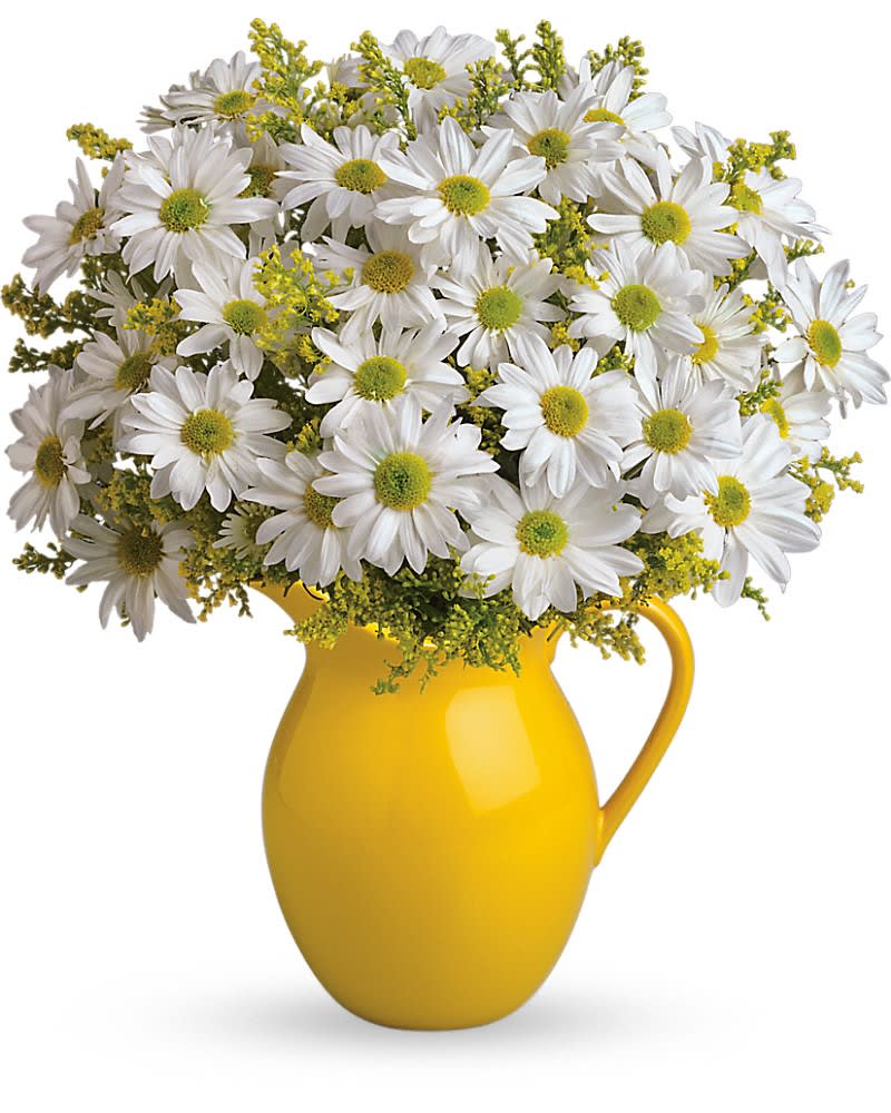 White daisy bouquet with yellow fillers arranged in a bright yellow ceramic pitcher