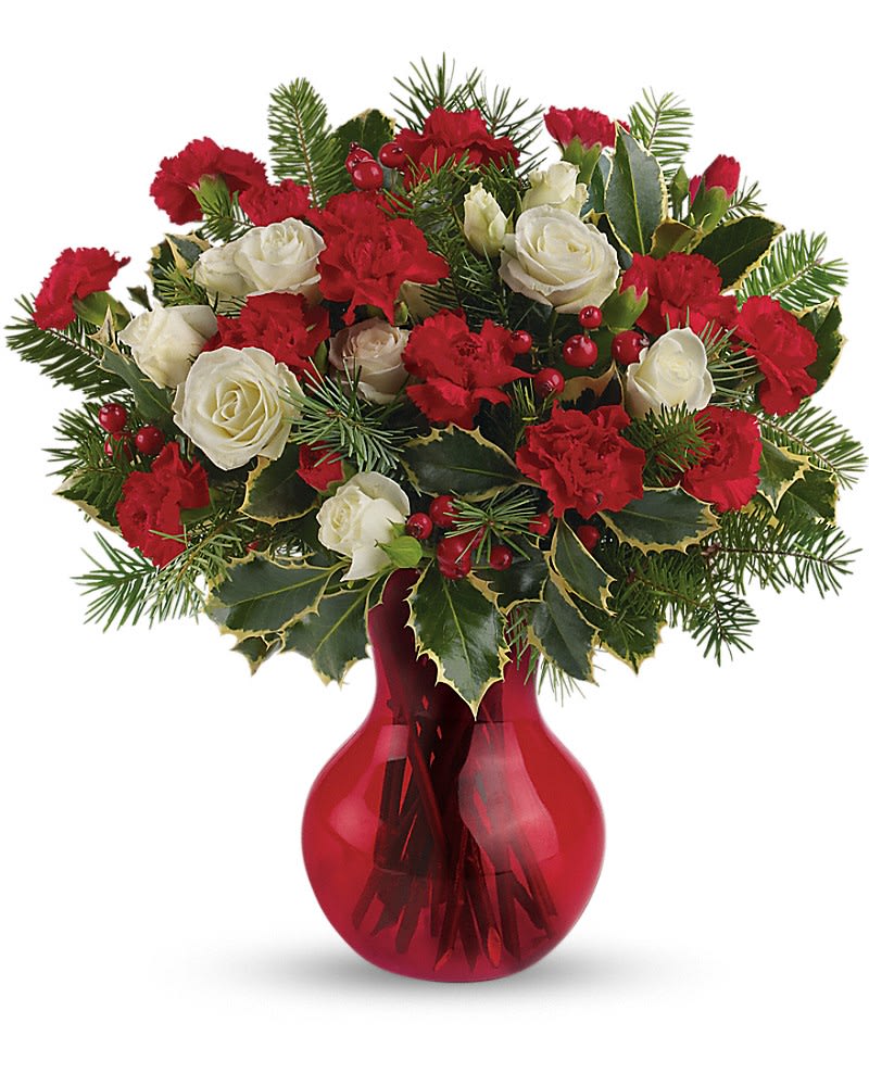 Red and white flower arrangement with evergreens in a red glass vase
