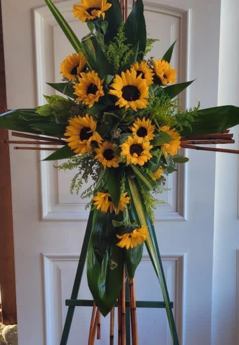 Standing sunflower spray on an easel with dark green foliage