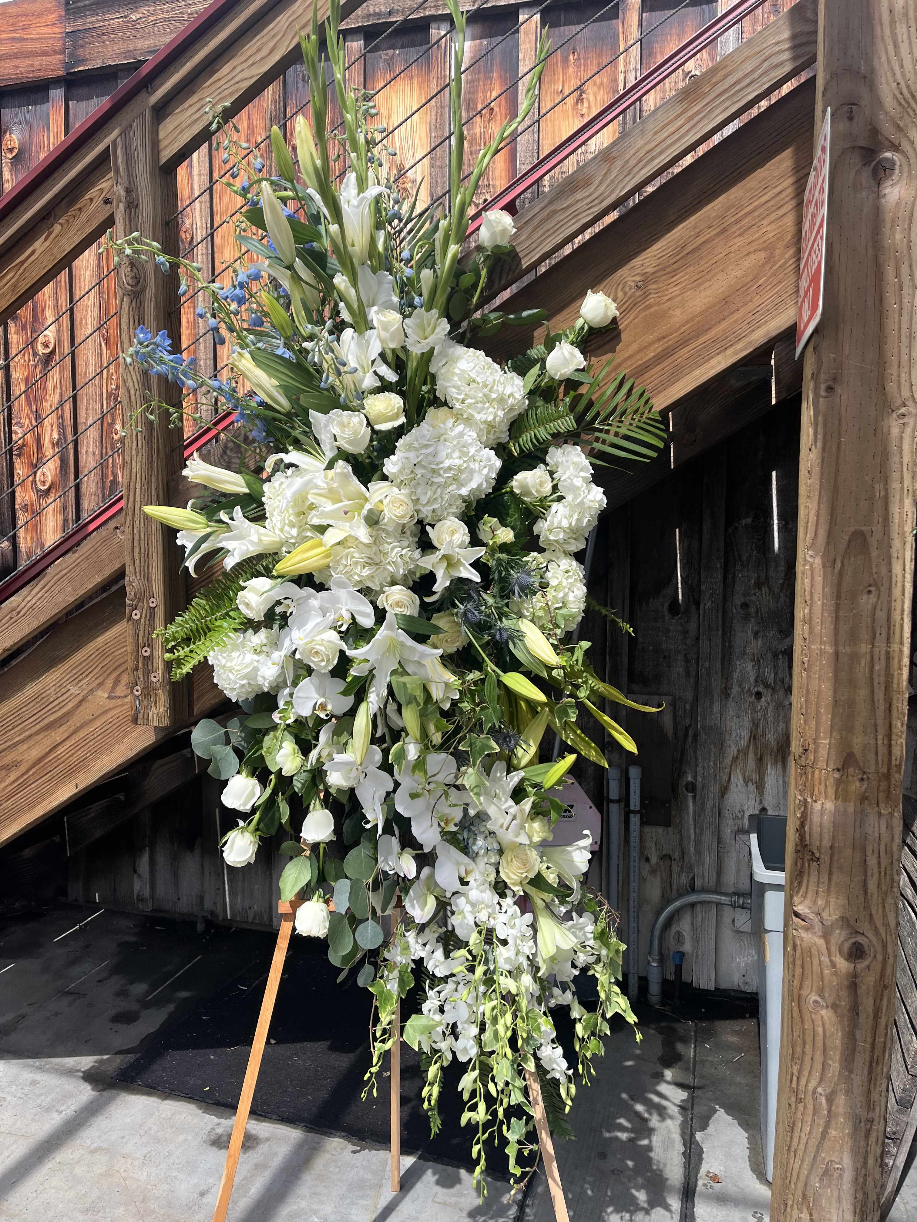 Tall white floral standing spray on an easel