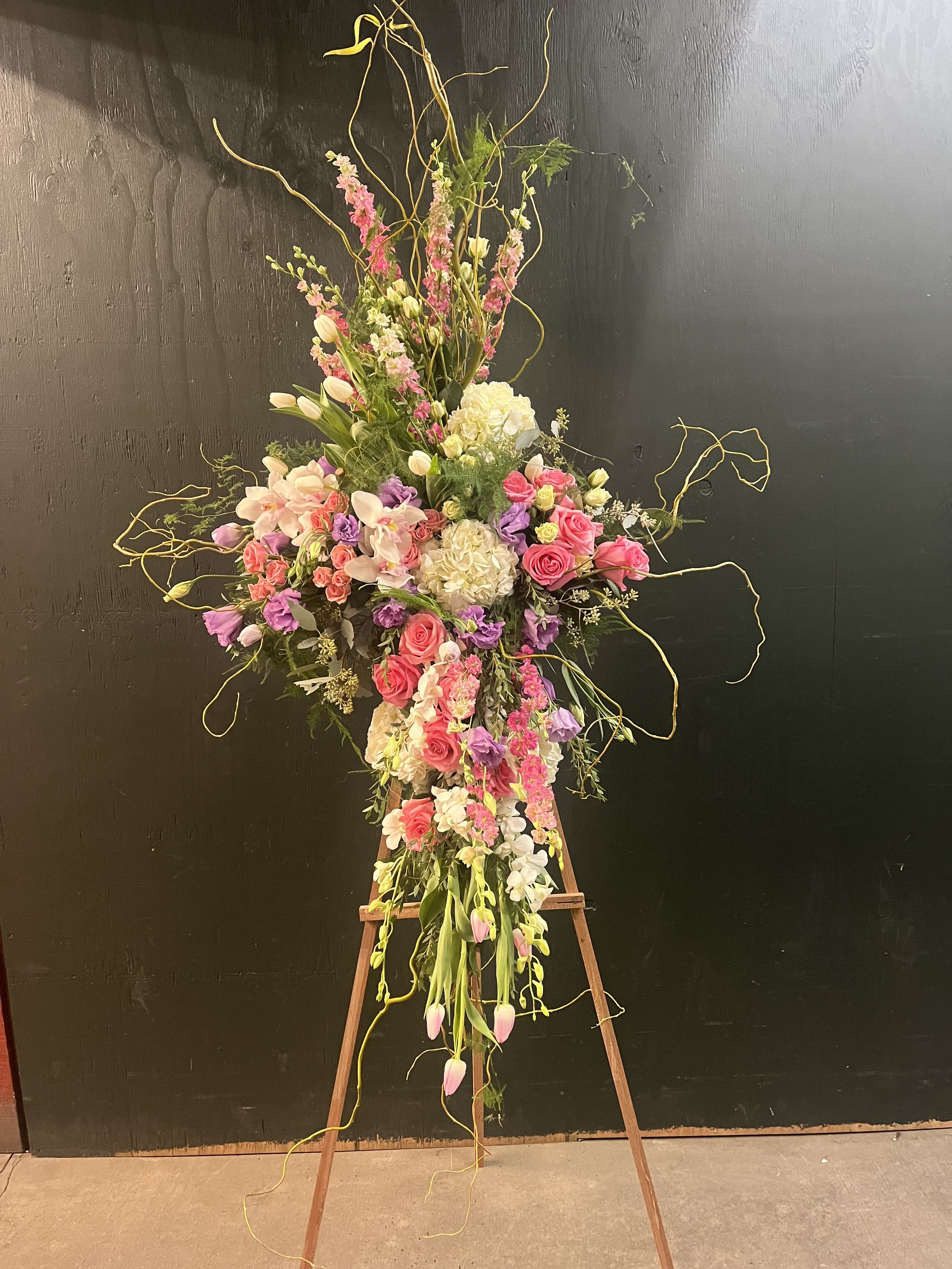 Tall floral spray with pink and white blooms on an easel