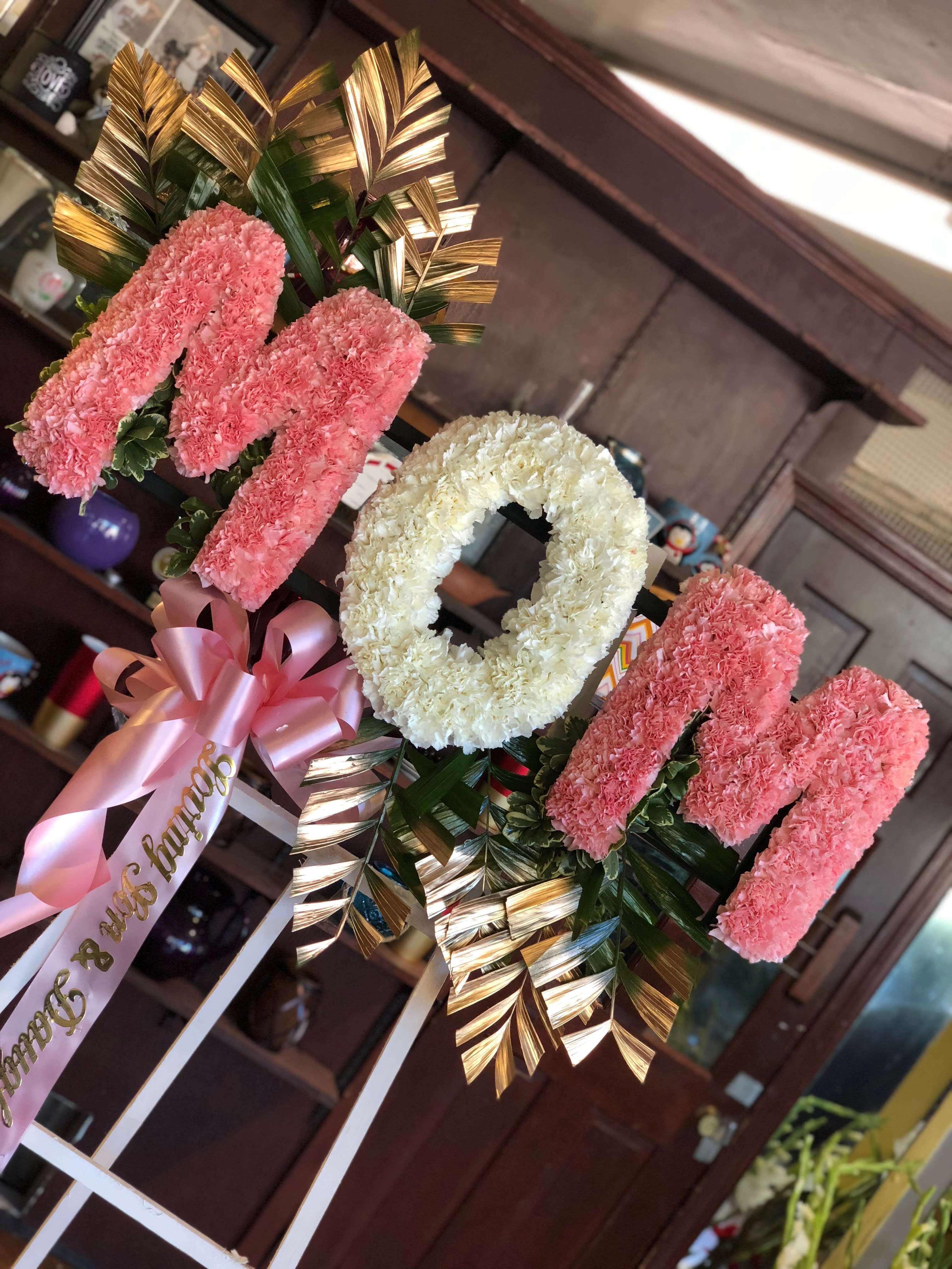 Pink and white floral standing arrangement with a ribbon bow