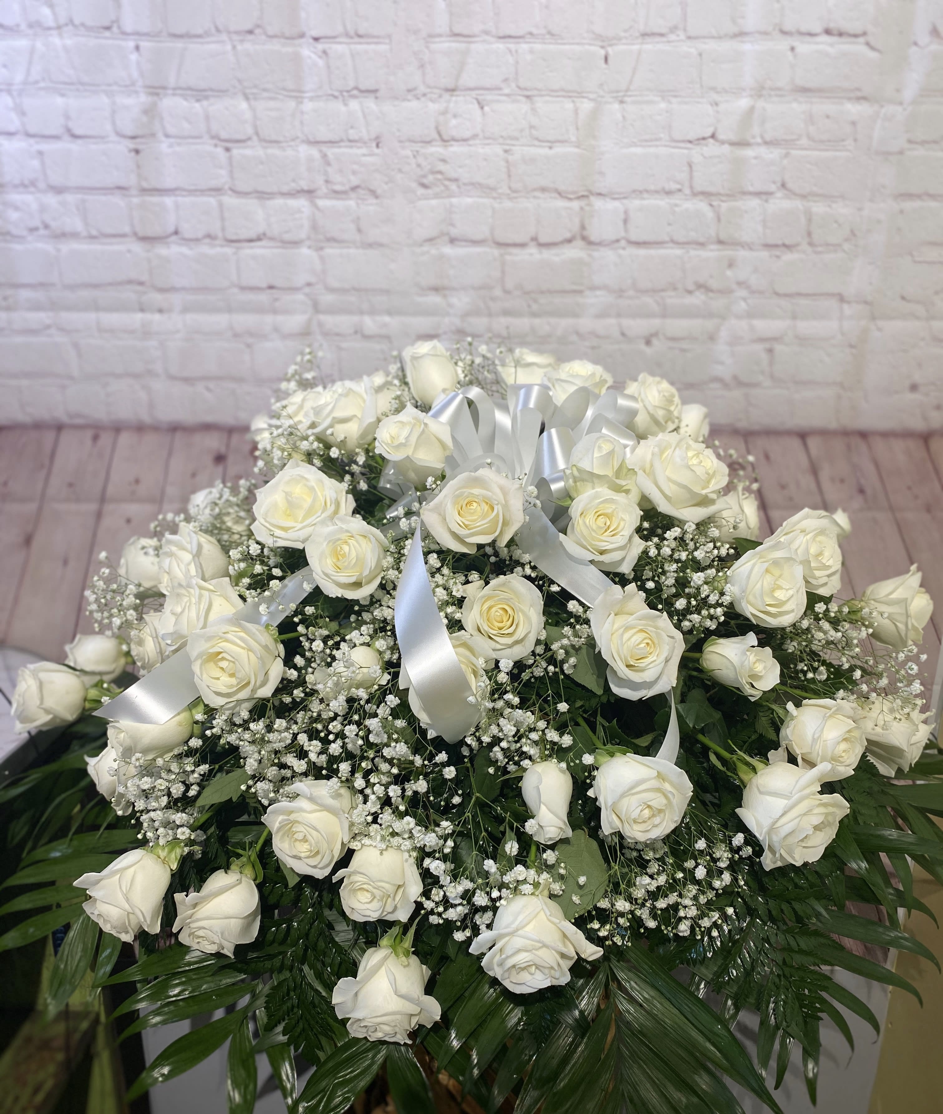 Large white rose arrangement with baby's breath and silver ribbon