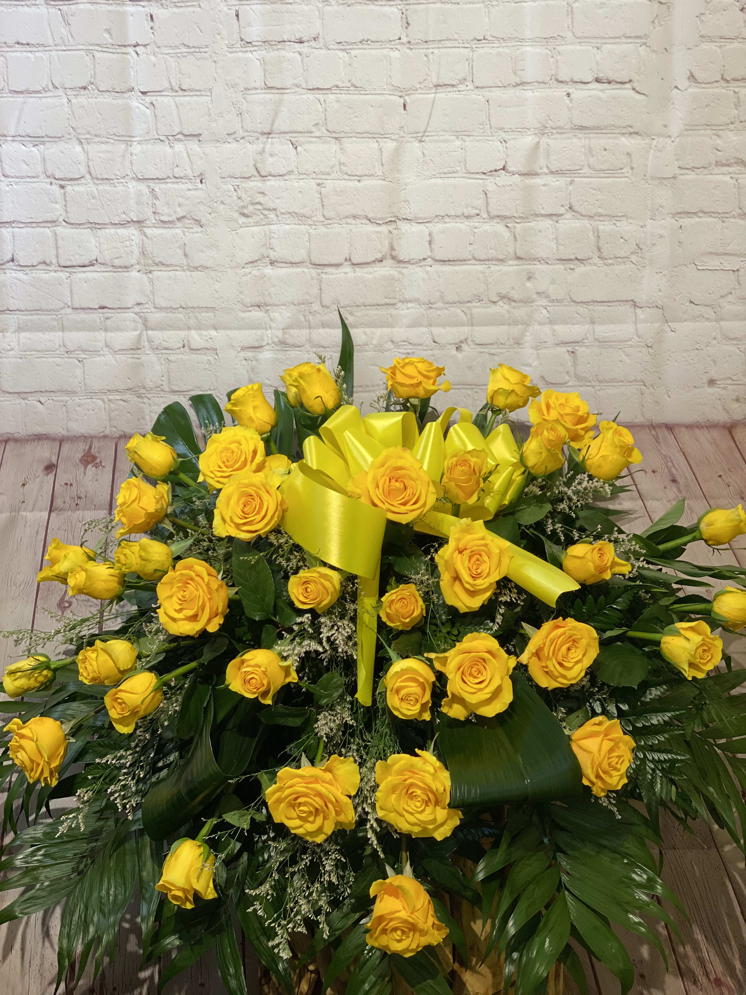 Large yellow rose arrangement with a bright yellow ribbon