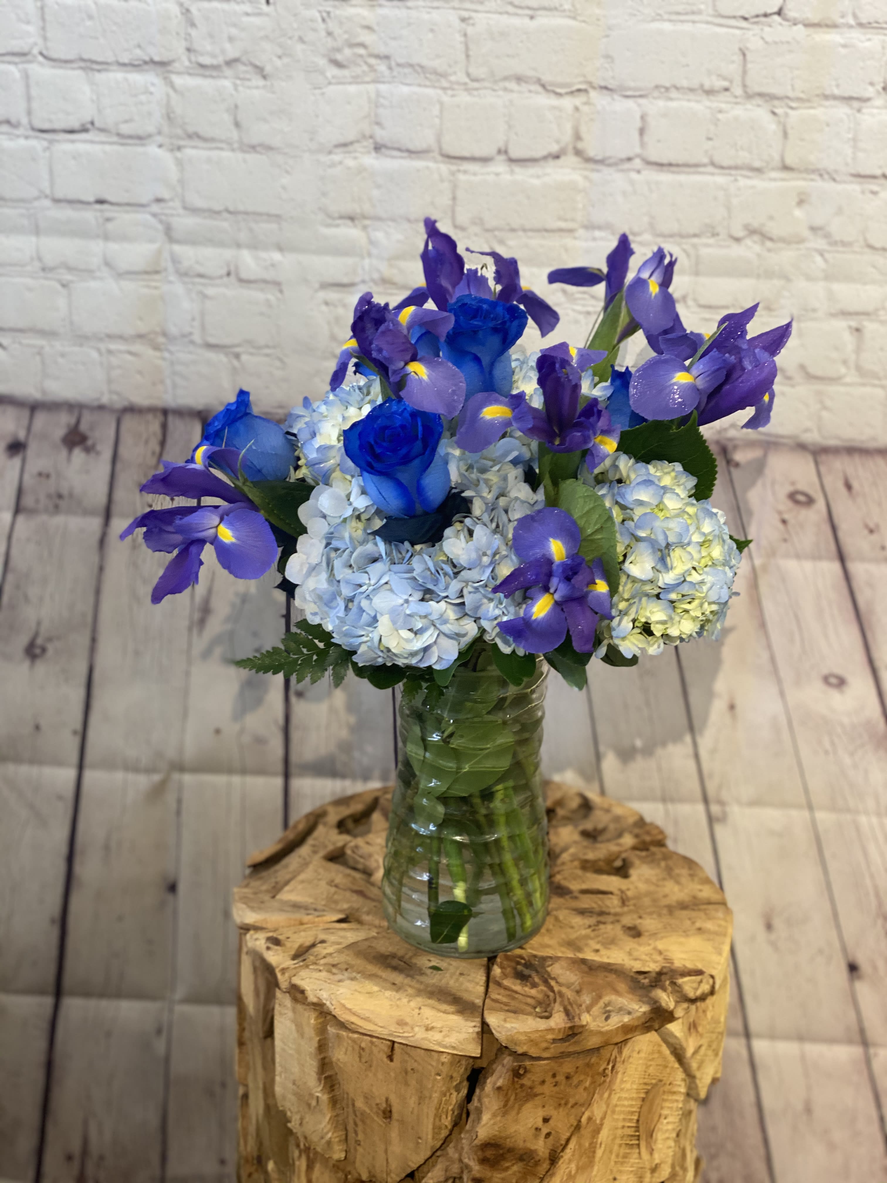 Blue roses and purple irises in a glass vase