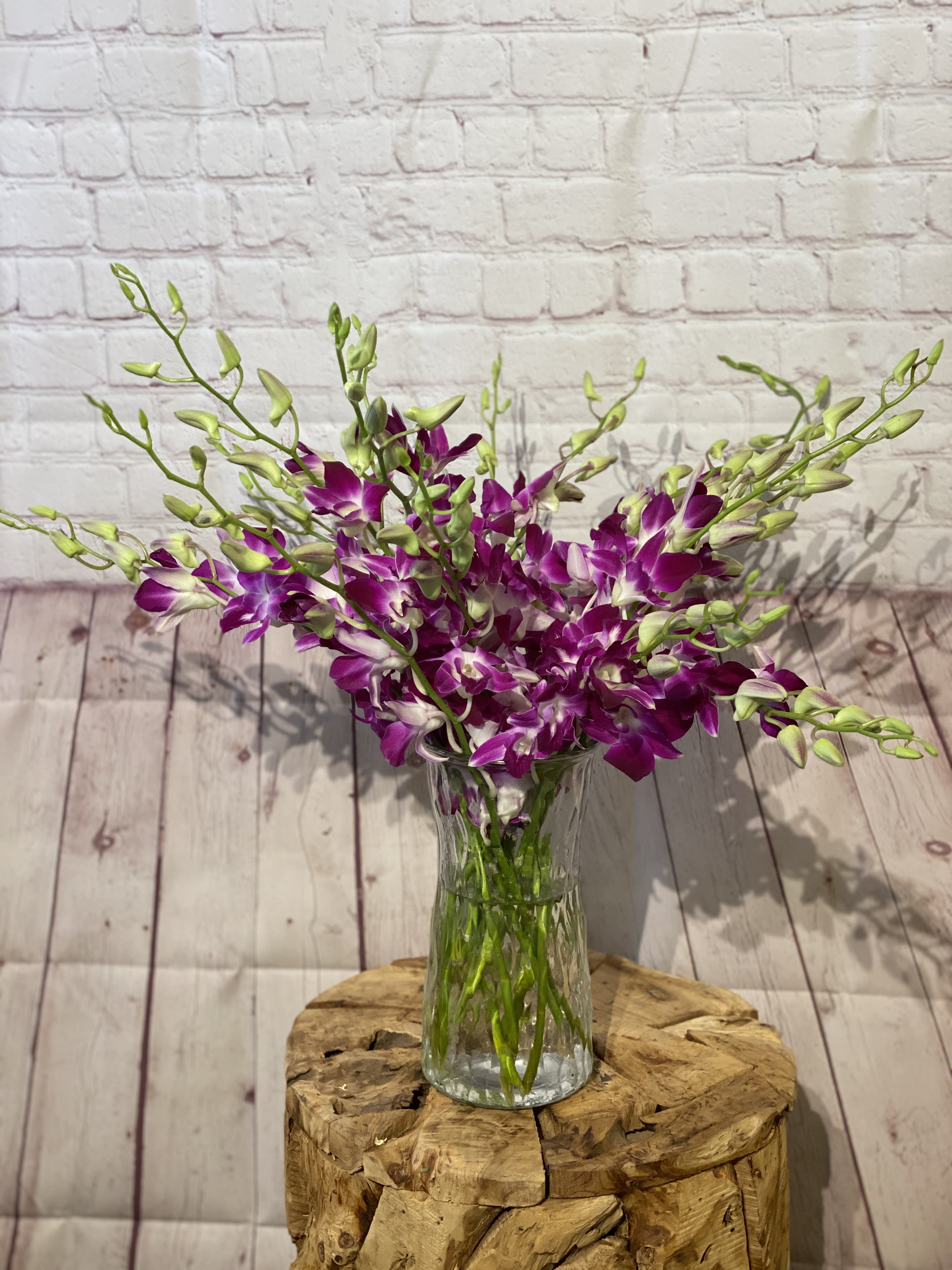 Purple orchids arranged in a clear glass vase