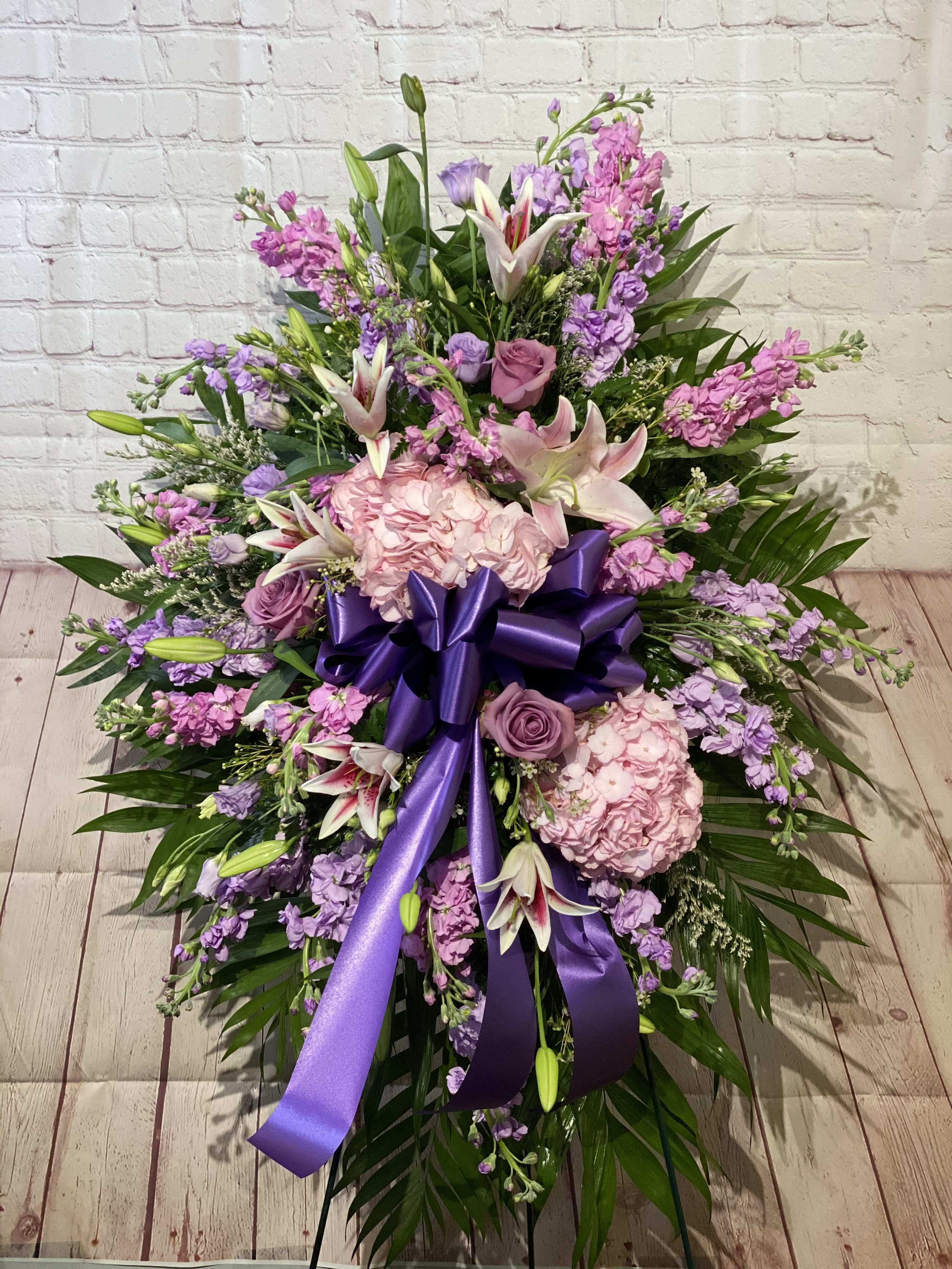 Large pink and purple floral spray with a purple ribbon bow