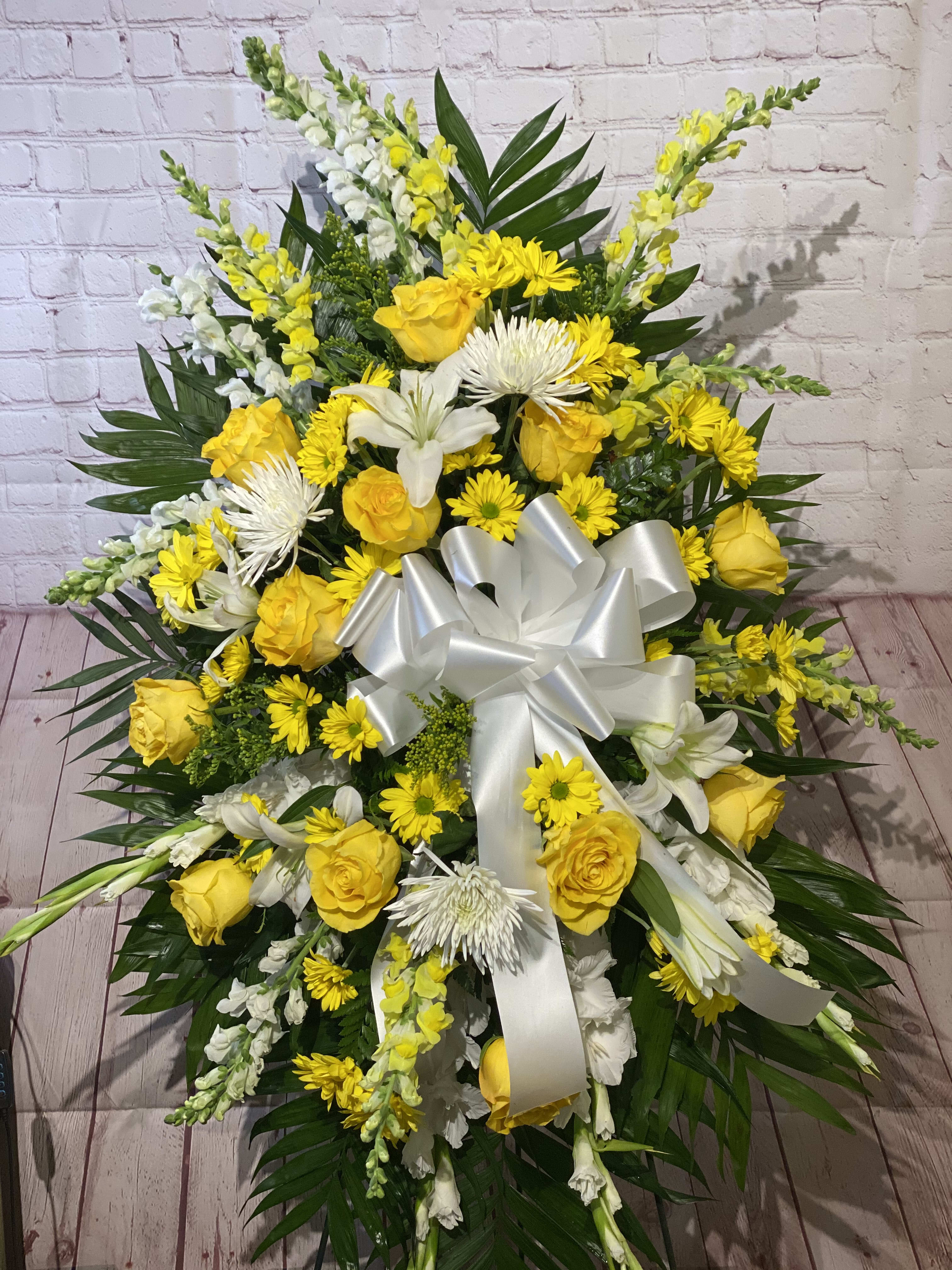 Large yellow and white floral spray with a white ribbon bow