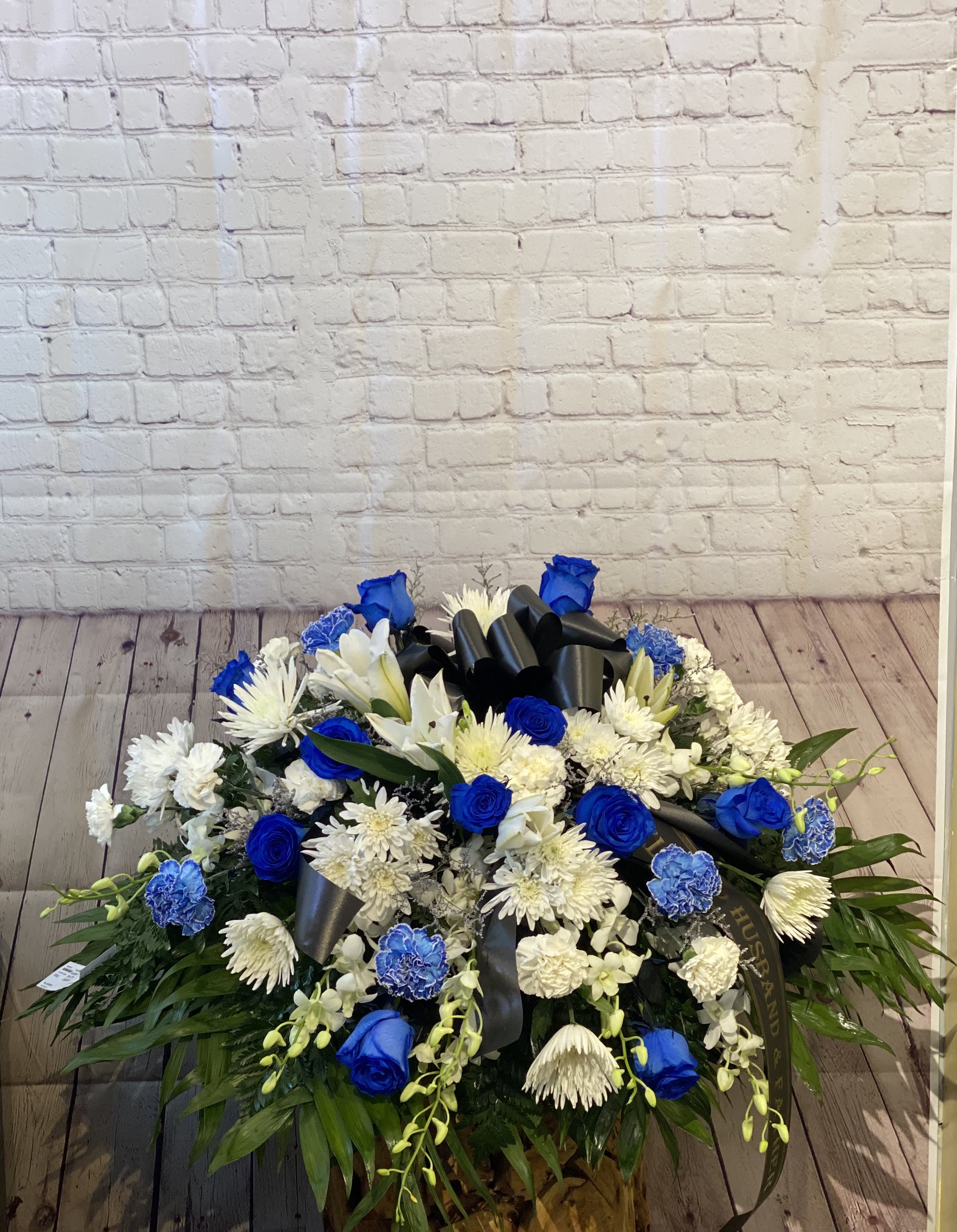 Blue and white floral spray with a black ribbon bow