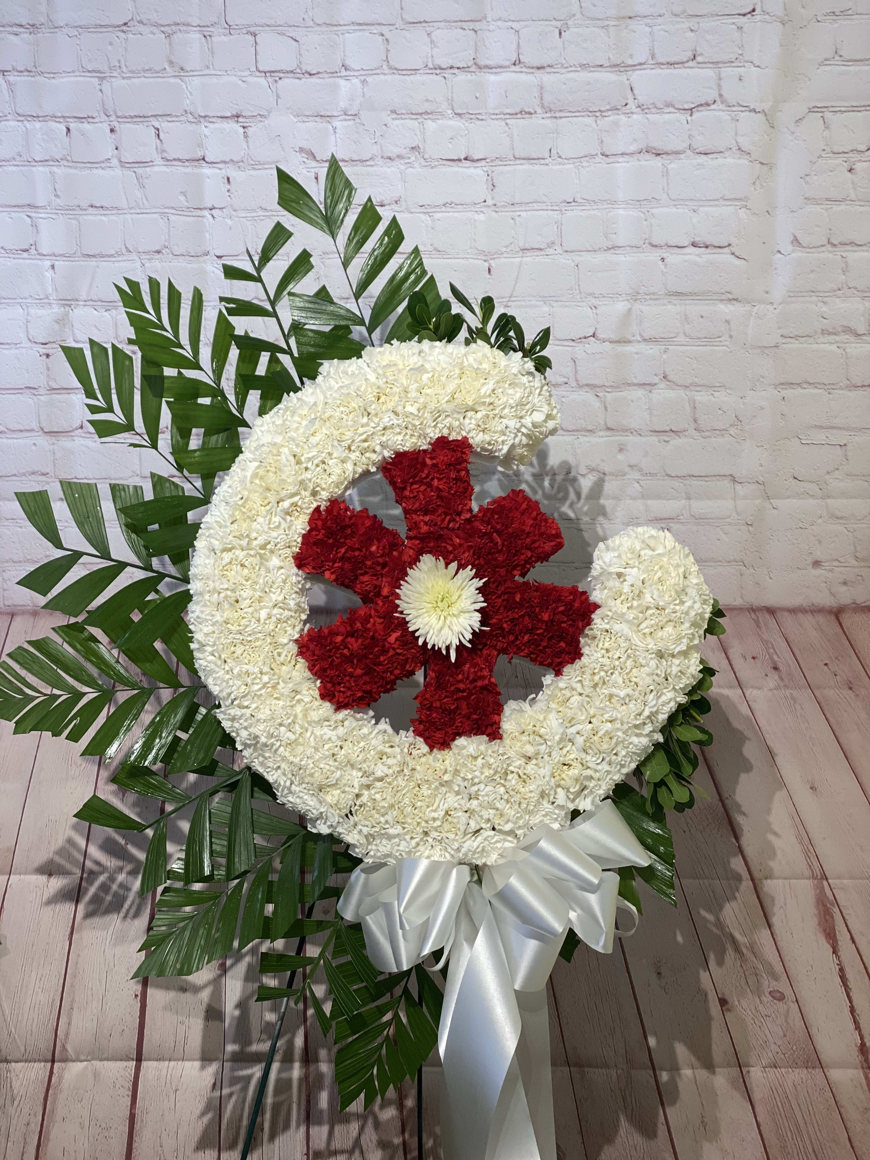 Large floral wreath with red and white flowers and a white ribbon bow