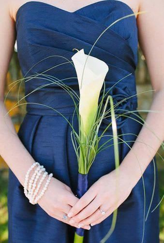 Woman holding a white calla lily bouquet with long grass accents