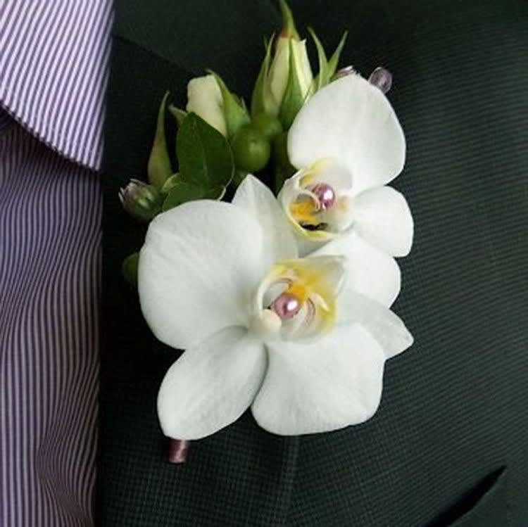 White orchid boutonniere pinned to a dark suit jacket