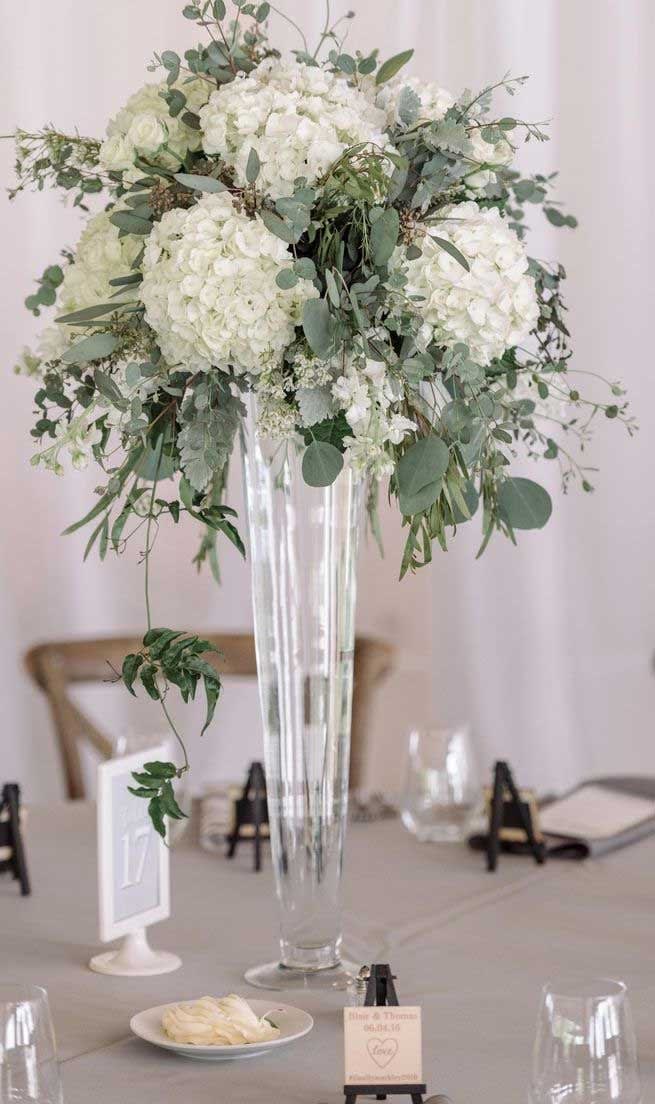 White floral centerpiece in a tall clear vase