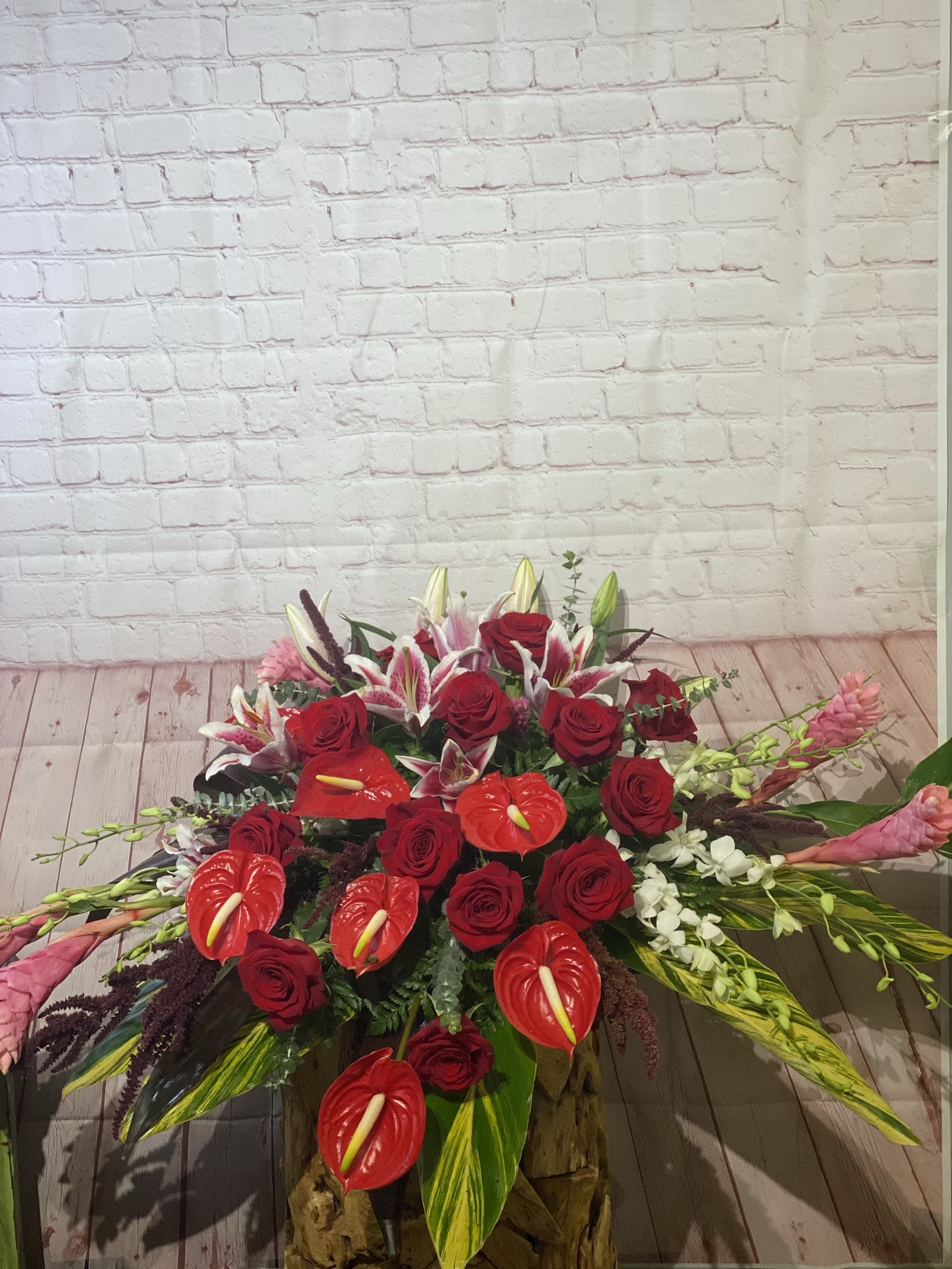 Large red floral arrangement with roses, lilies, and anthuriums