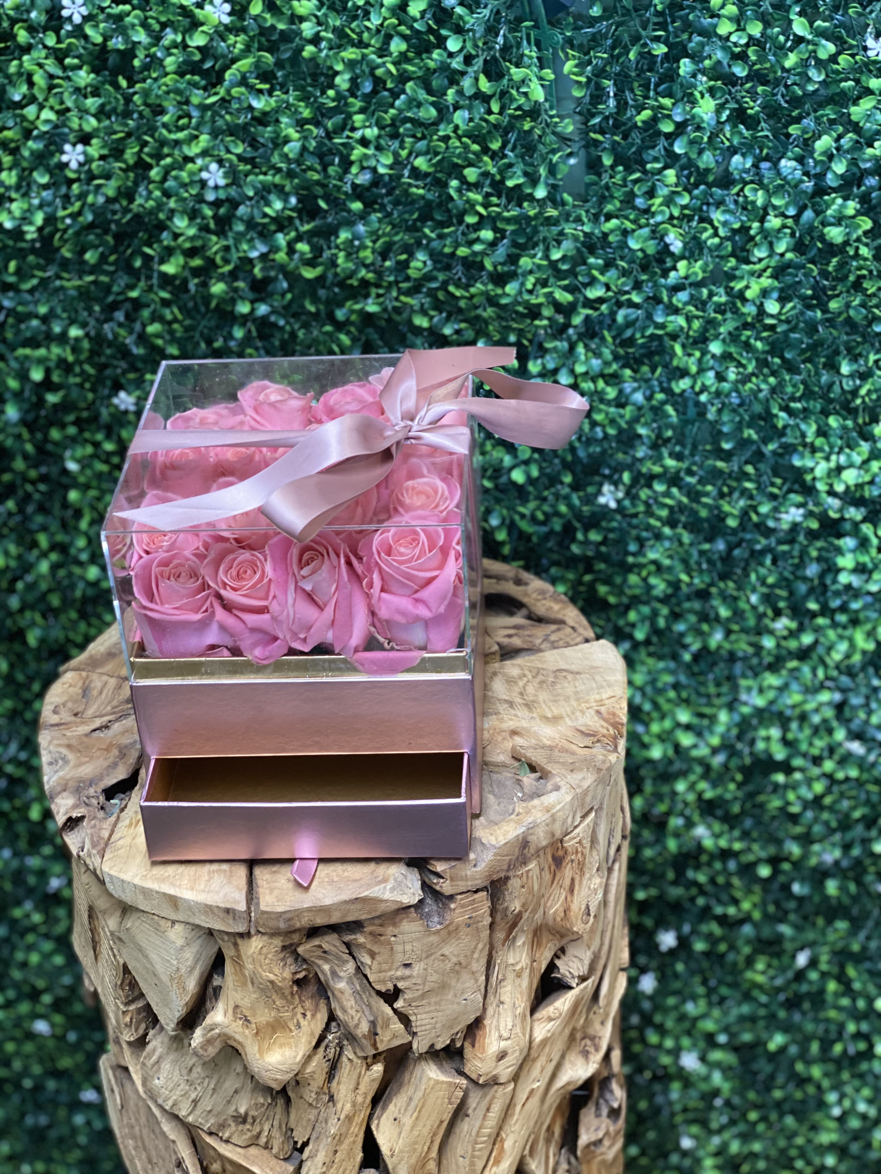 Pink roses in a clear gift box with a ribbon